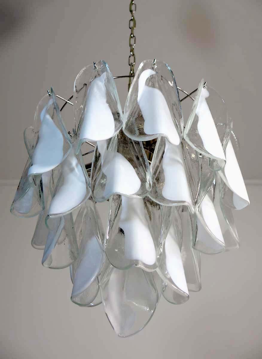 Rare Italian vintage Murano chandelier. The fixture is made up of 24 individual hand blown glass elements hanging (transparent and white “lattimo”) from a chrome frame. Each piece clear with white centre.
Period: 1960s-1970s
Dimensions: 46.45