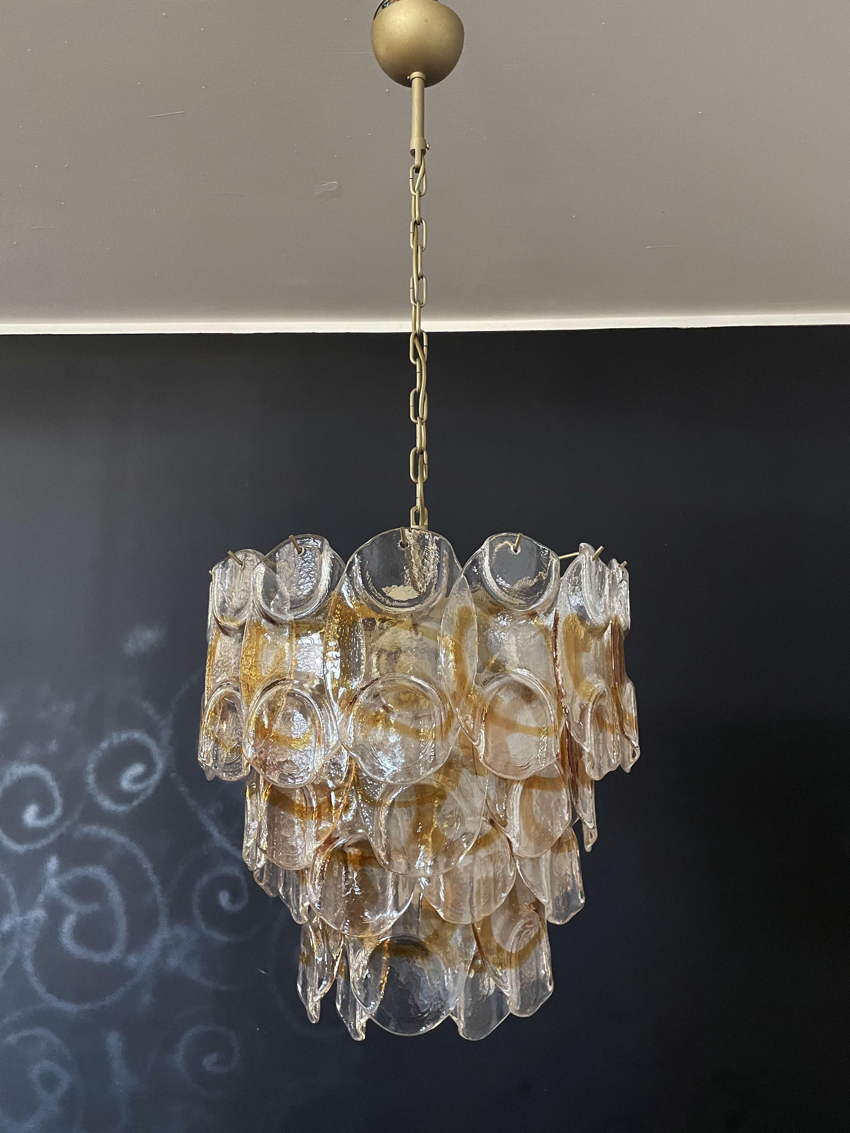 Rare Italian vintage Murano chandelier. The fixture is made up of 41 individual handblown glass elements hanging (transparent and amber) from a gold painted metal frame. Each piece clear with amber centre.
Period: late XX century.
Dimensions: