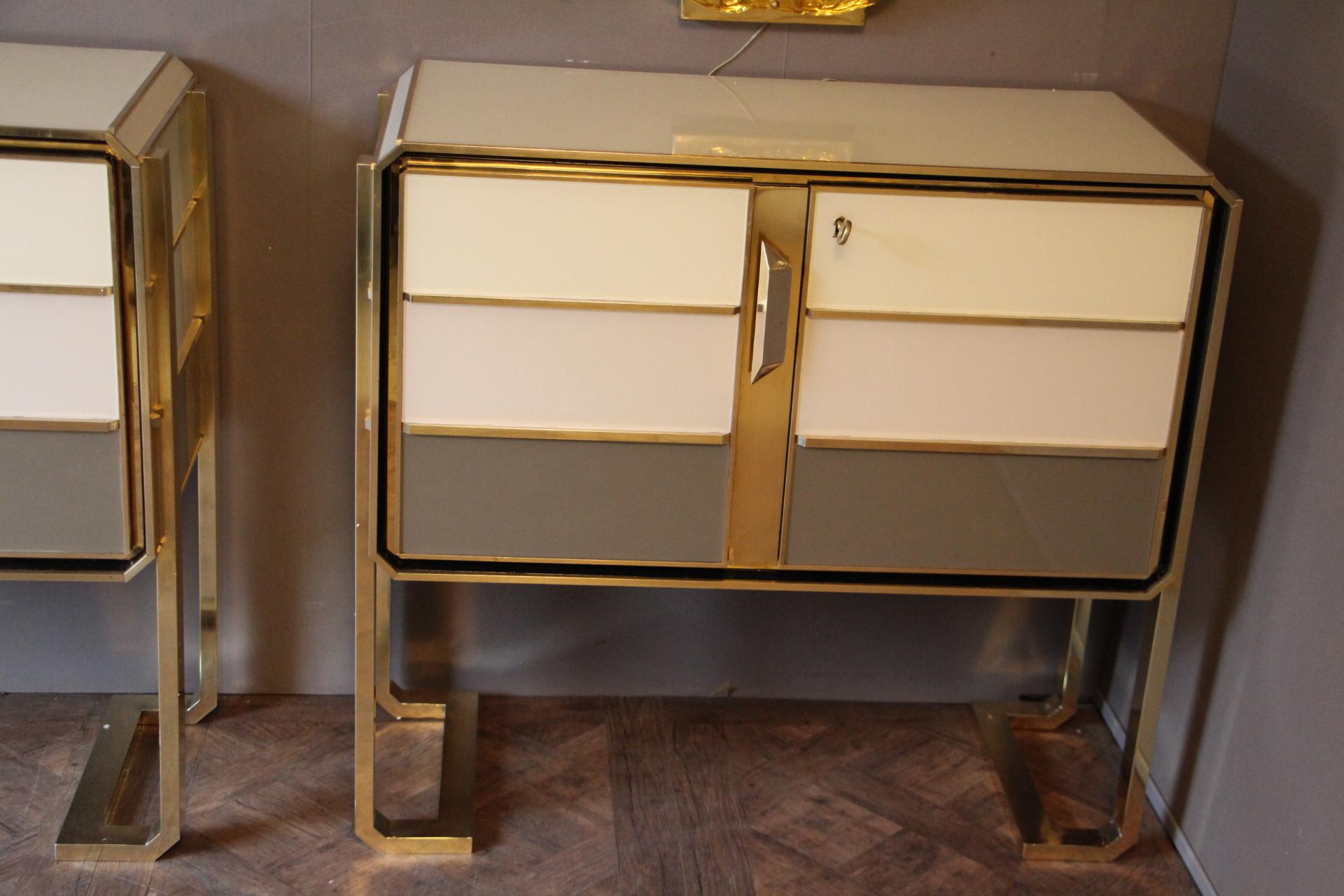 Superb pair of Italian fine design one of a kind cabinets in golden polished brass, ivory white, beige and grey color Murano glass featuring 2 doors. The top is covered in beige color Murano glass.
Solid wood structure.
These cabinets have been