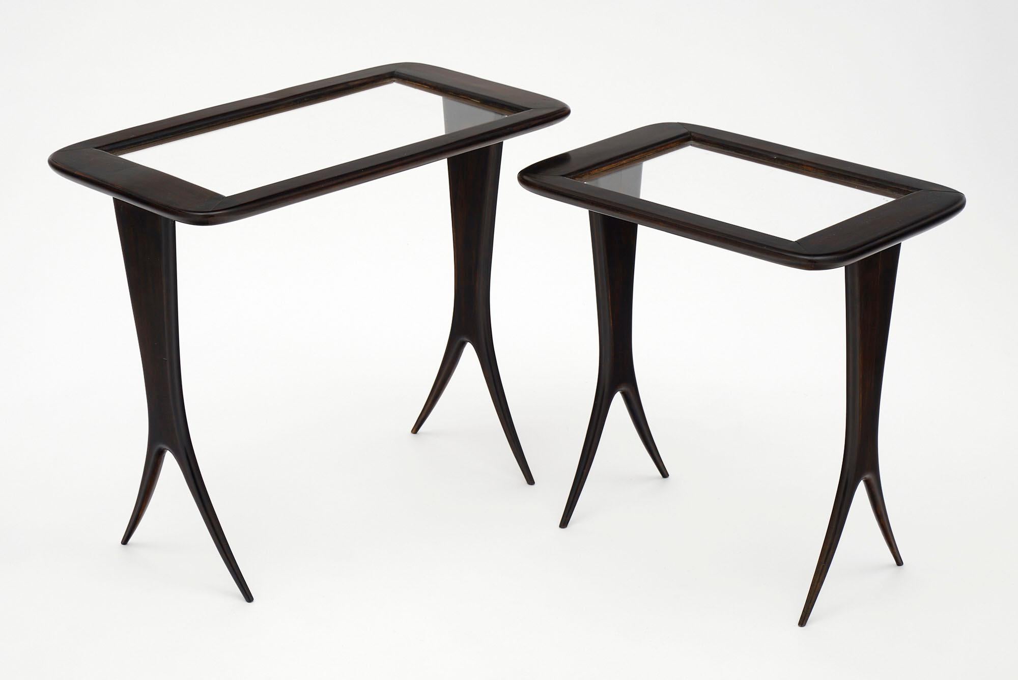 Pair of nesting tables from Italy made of ebonized mahogany and finished in a lustrous French polish. This elegant pair has split flaring legs in the style of Paolo Buffa and glass tops. The listed measurements are for the larger table. 

Small