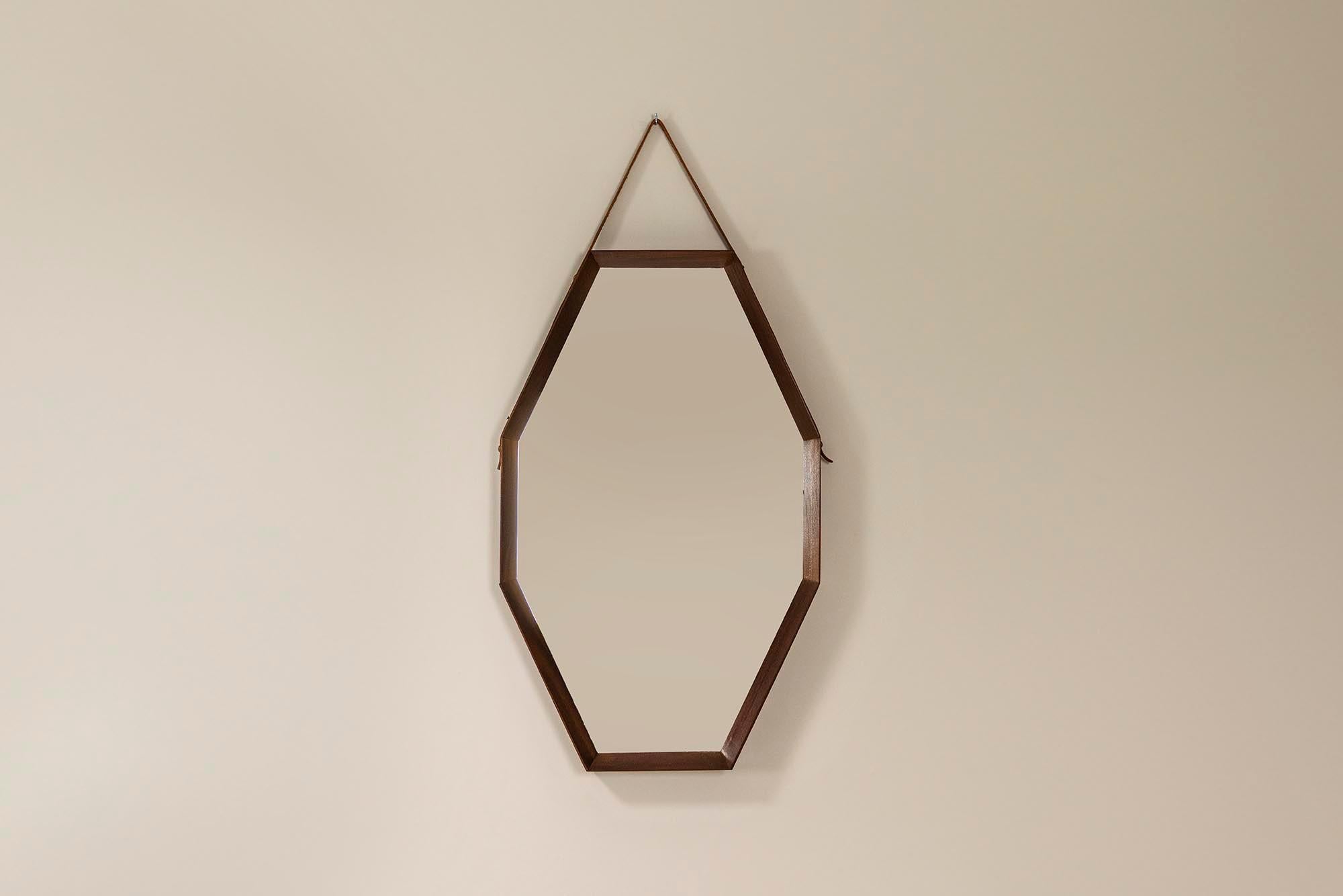 Joli miroir vintage italien qui respire l'élégance du milieu du siècle avec une touche de modernité. Fabriqué à la main en bois de teck, ce miroir octogonal présente des lignes épurées qui allient un design intemporel à une touche contemporaine. Les