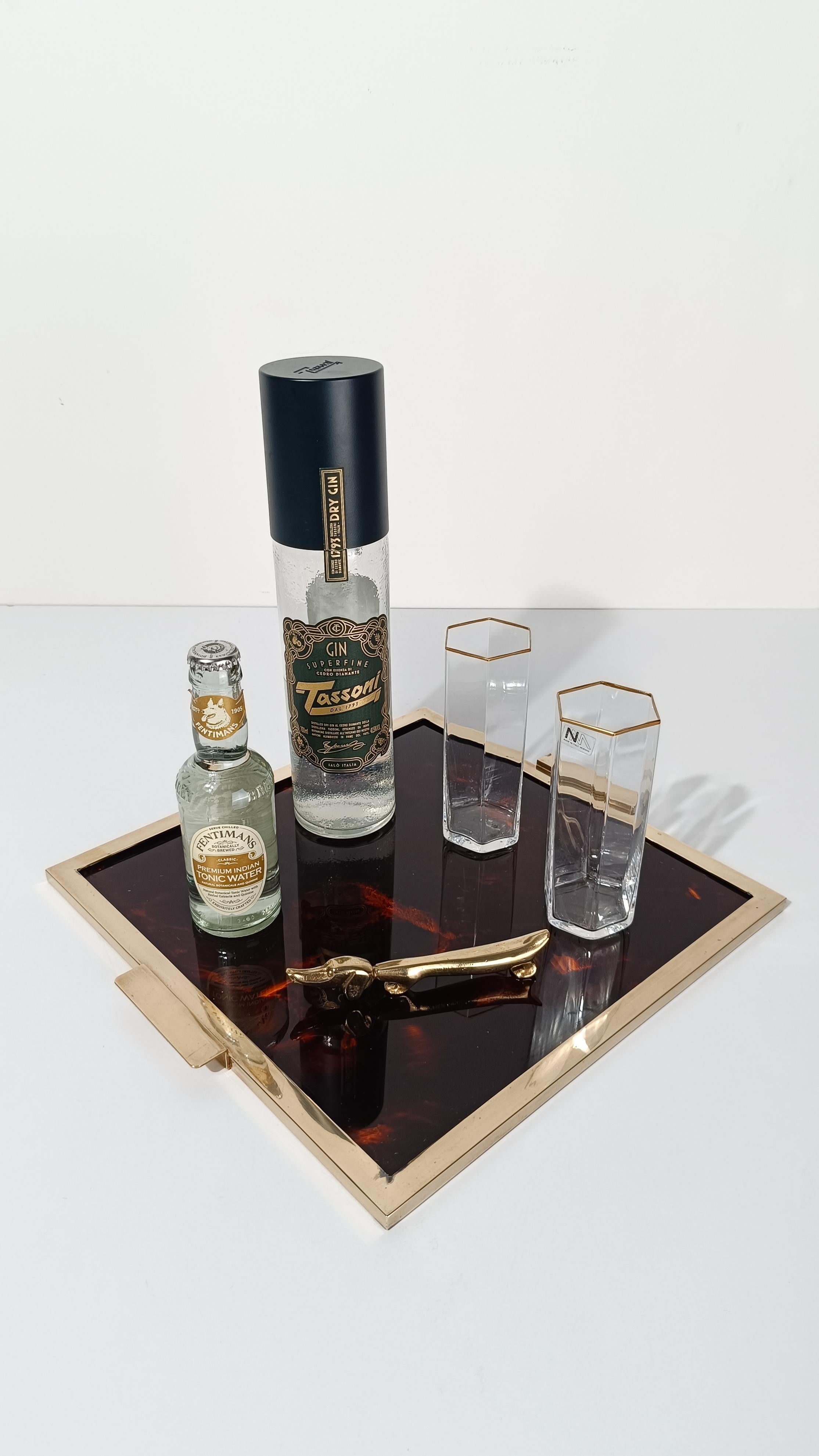 Square tray made in Italy undoubtedly dating back to the 70s.
Made with a 3 mm thick quadrangular faux tortoise lucite panel enclosed in a solid brass frame with removable handles.
The design and materials used to create this vintage tray can be