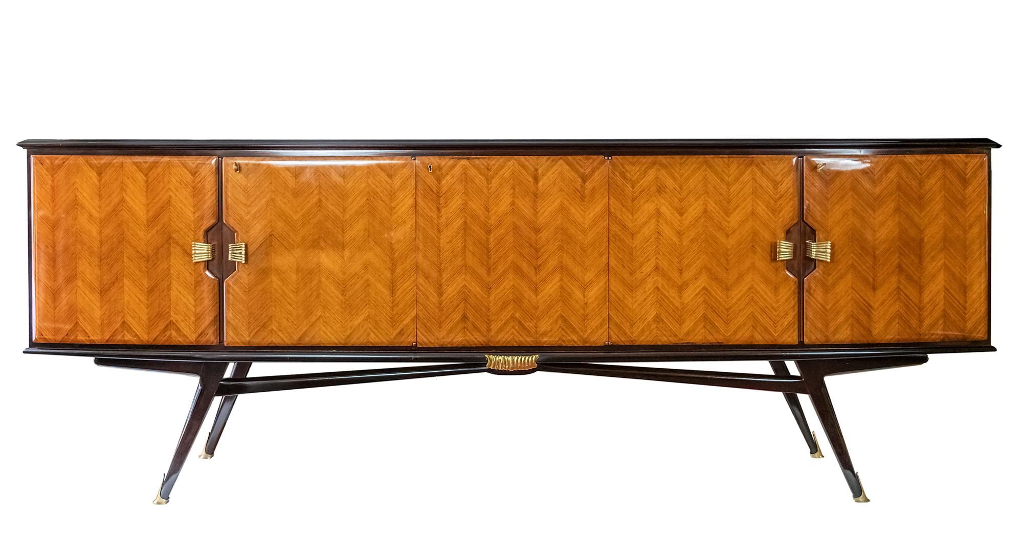 Italian vintage wood veneer sideboard from 1950s in the style of Paolo Buffa or Vittorio Dassi.
Wood surface is varnished, the doors are decorated with brass handles and keys.
Side parts are with shelves inside, the central part inside is for bar