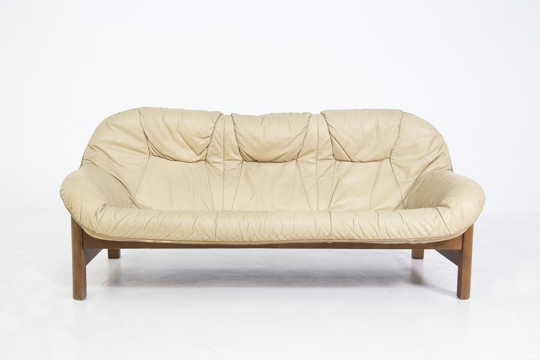 Vintage Italian-made sofa from the 1960s.
The sofa is made with a wooden frame and with a one-piece cushion that wraps around and covers both the seat and the back in beige leather.
The leather seat is so comfortable that it also wraps around the