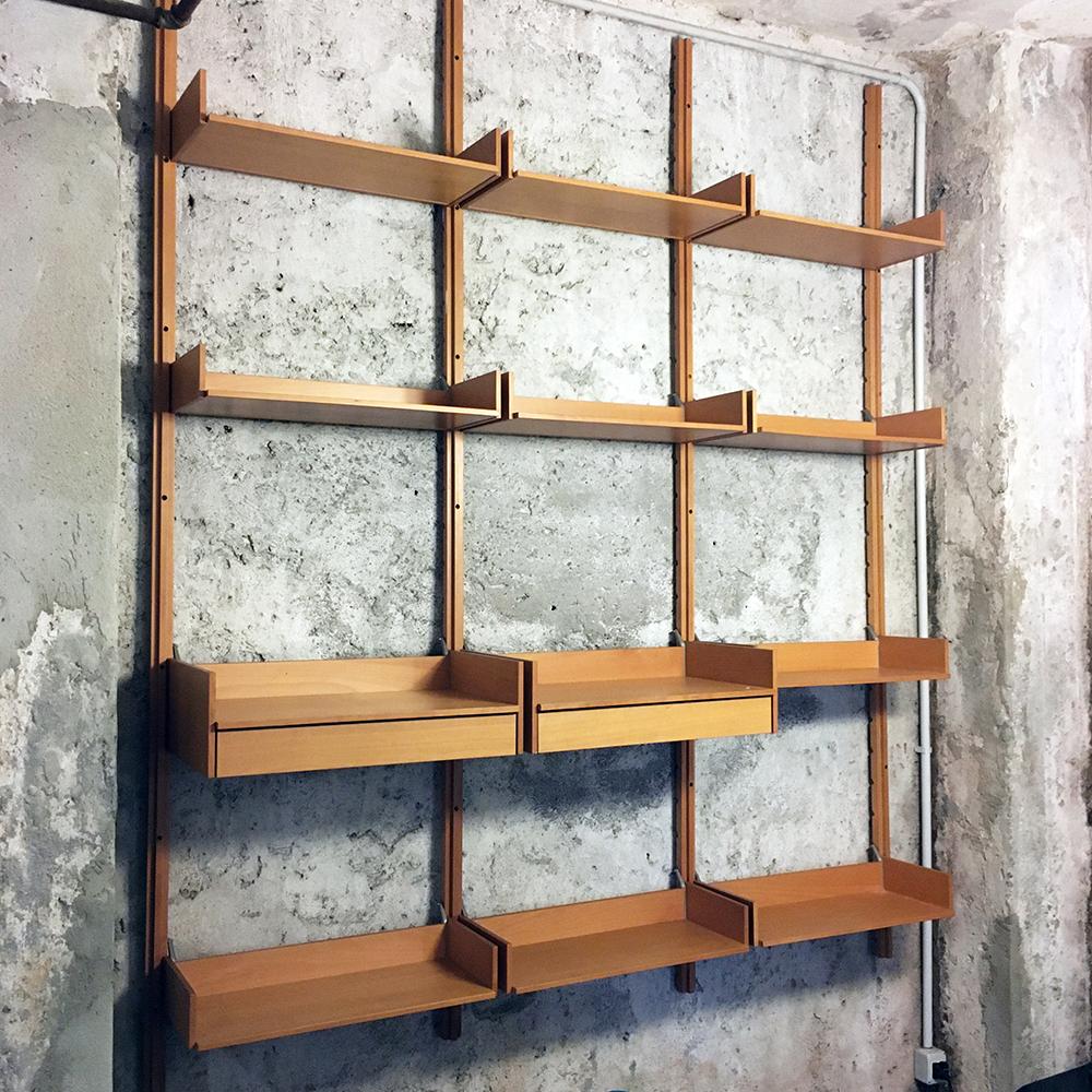 Italian vintage solid beech wall bookcase, 1990s
Solid beech wall bookcase from 1990s, with tray shelves, two drawers and aluminum shelf support. Possibility to position it as a bookcase from the ground, however fixing it to the wall, with the use