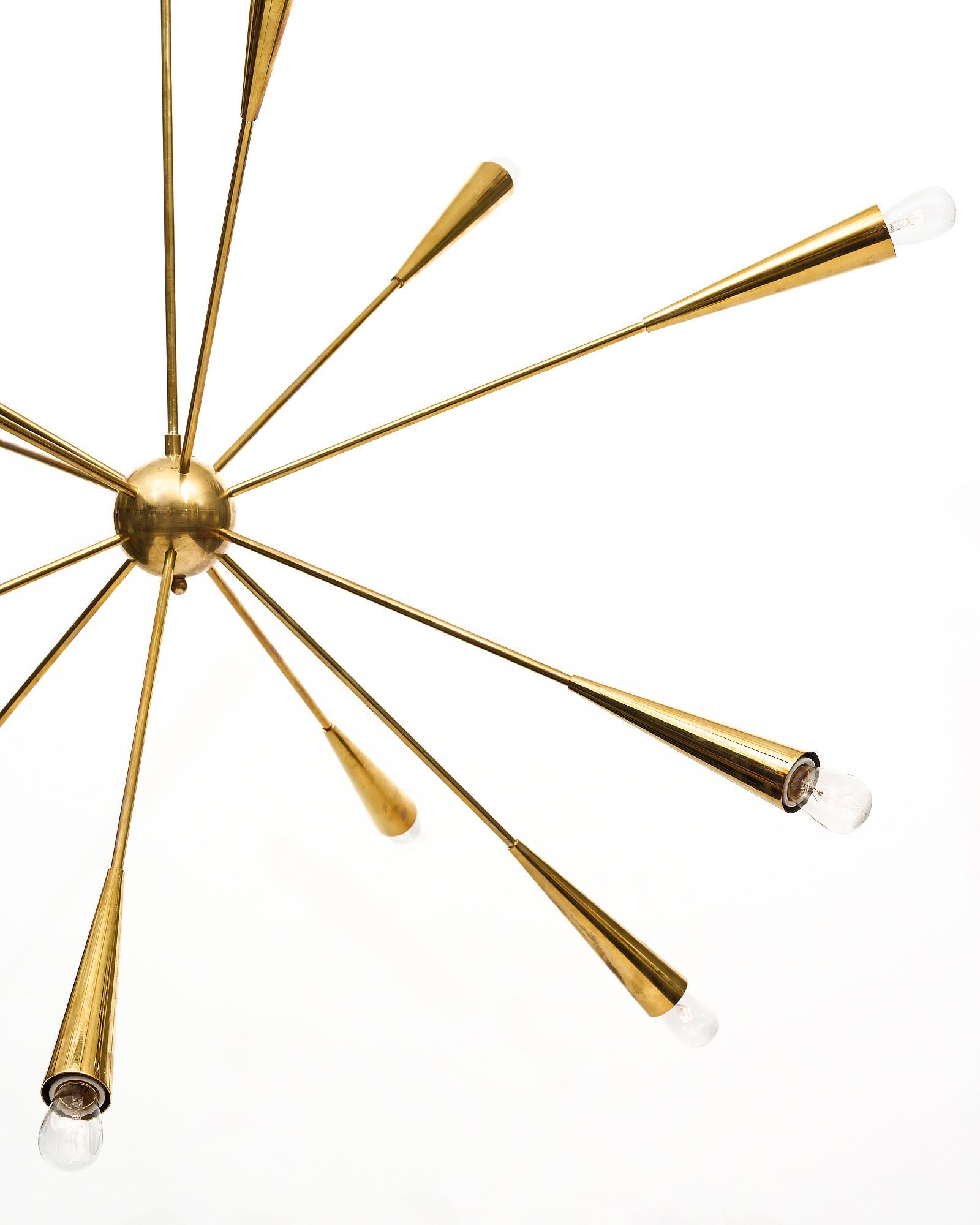 Sputnik chandelier from Italy made of brass. There are twelve arms erupting from a central brass globe finishing with a conic design. Each arm is lit from the end and has been newly wired to fit US standards.