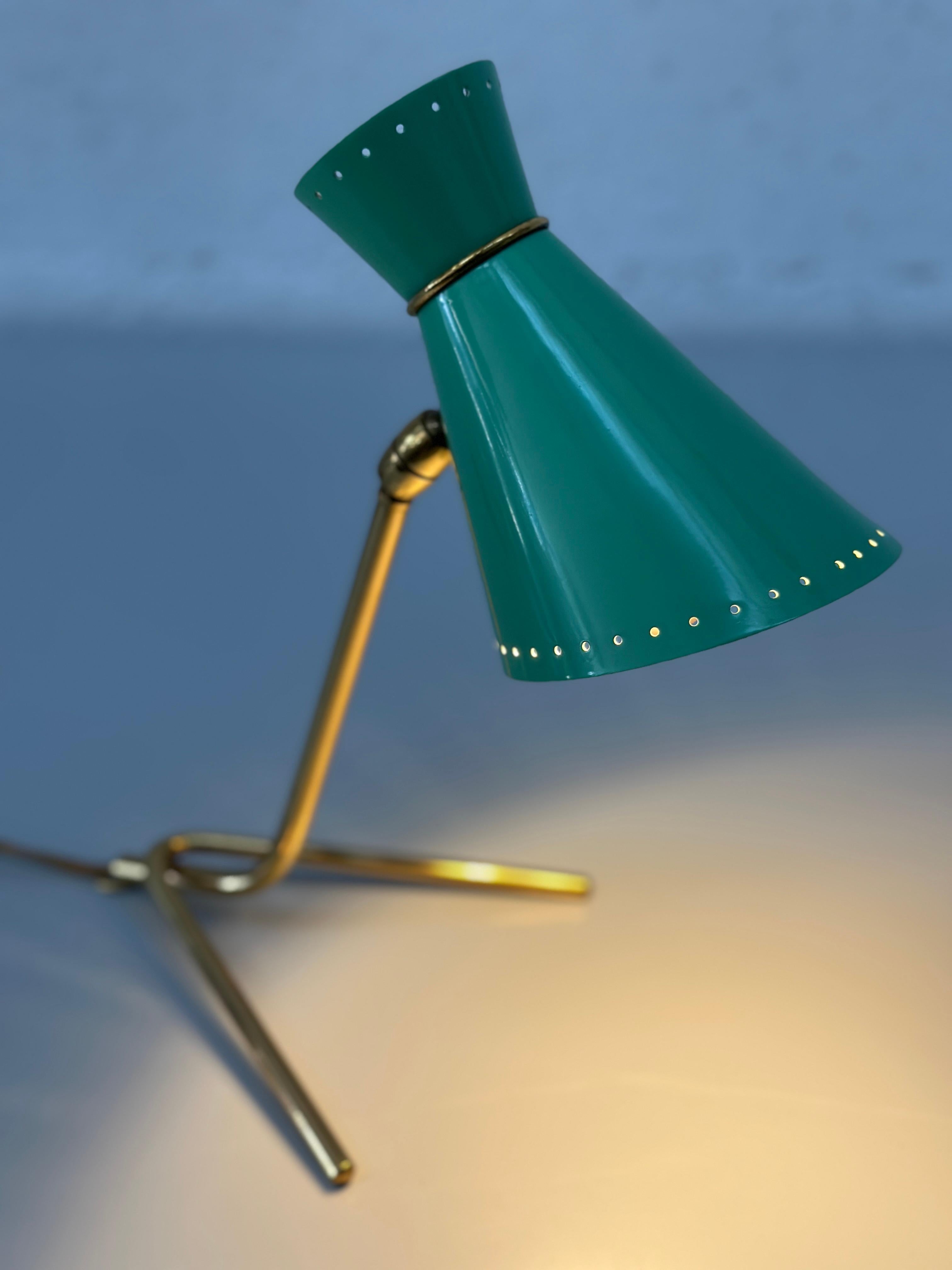 Splendida lampada da tavolo italiana di metà secolo in verde pastello e ottone, risalente agli anni '50, che mette in mostra la raffinata eleganza dell'epoca.

La base minimalista in ottone e il paralume conico in metallo laccato verde conferiscono