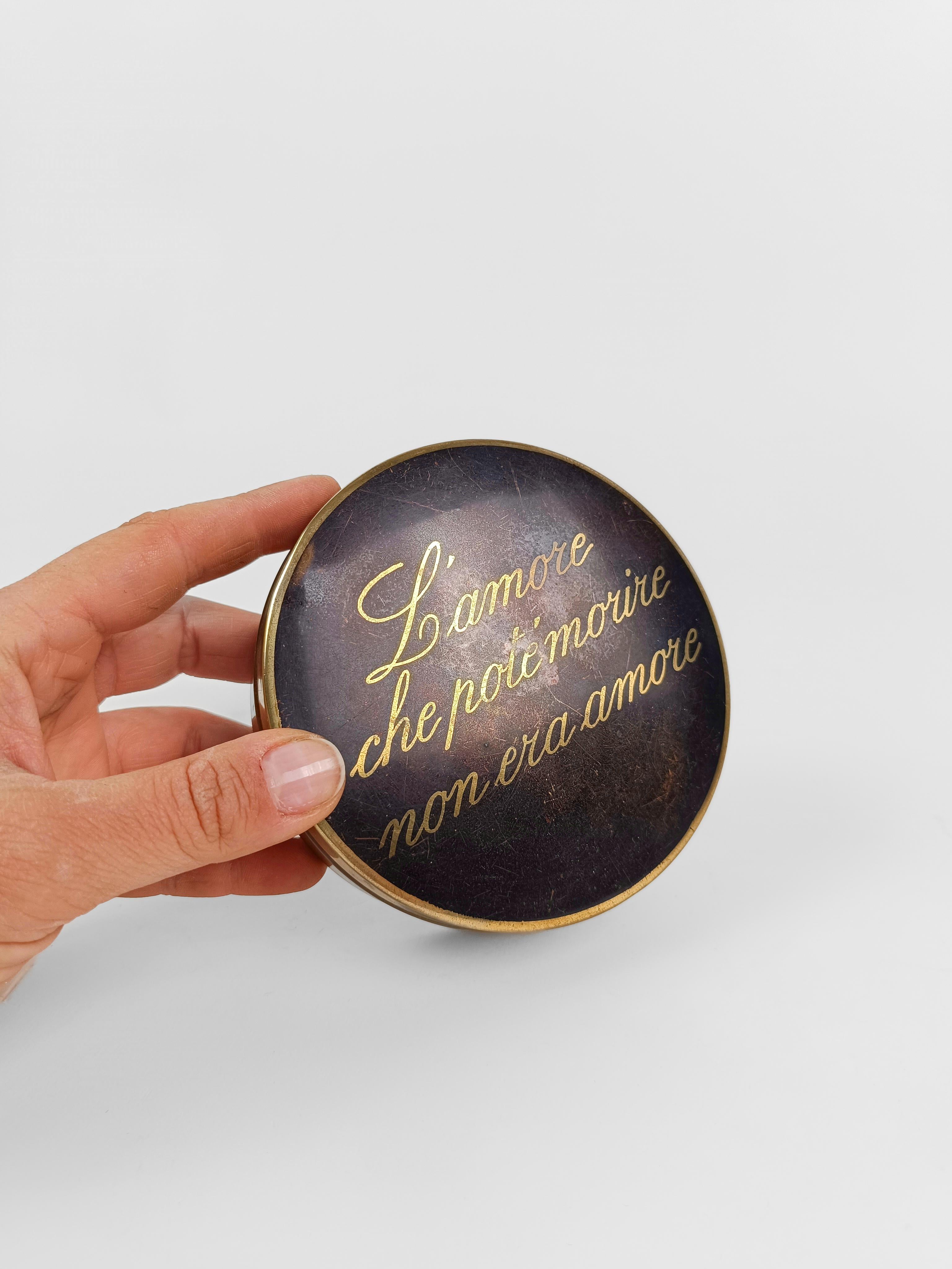 Scatola di latta rotonda vintage risalente agli anni '50 e '60.

Non sappiamo cosa contenesse in origine, ma immagino che contenesse un anello per una proposta di matrimonio irripetibile.

La frase serigrafata sul CAP recita in italiano un aforisma