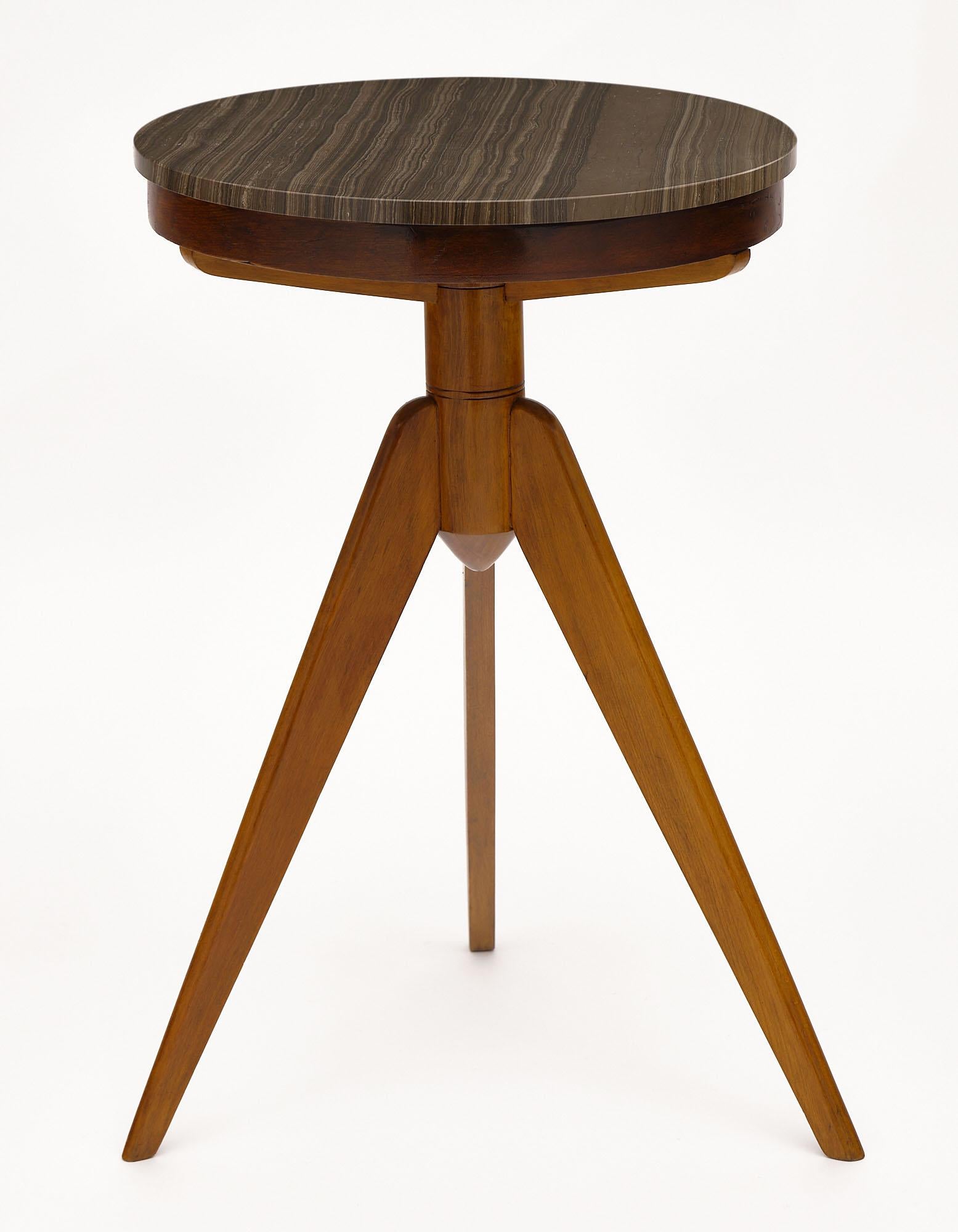 Side table from Italy made with a solid cherry wood tripod base topped with a veined gray marble from the Alps. This table is in the manner of Osvaldo Borsani.