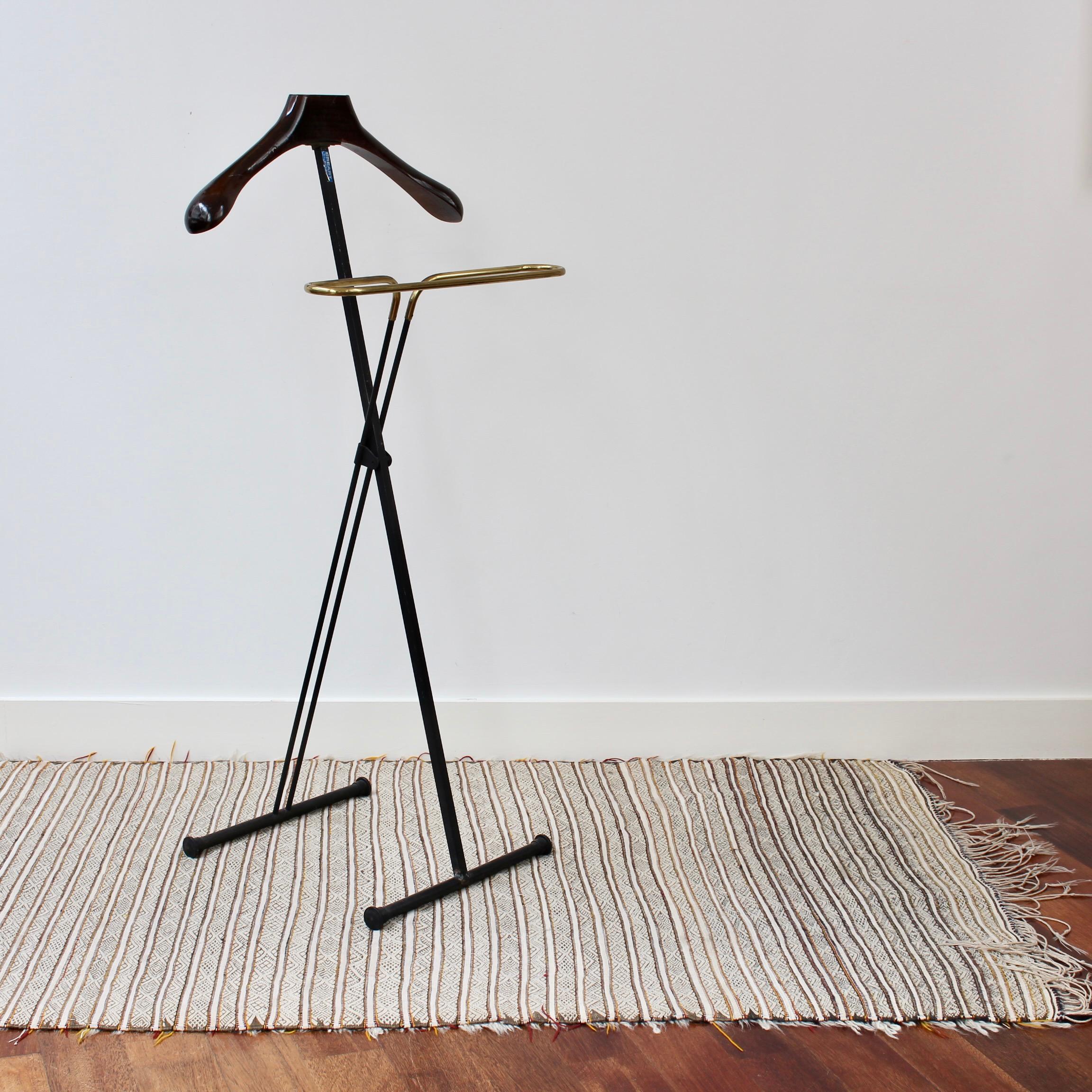 Vintage Italian valet coat stand (circa 1950s). Old world glamour and practicality all at once make this valet coat stand extremely appealing. The stand provides for a jacket or coat to be hung on the wooden piece while trousers fold over the