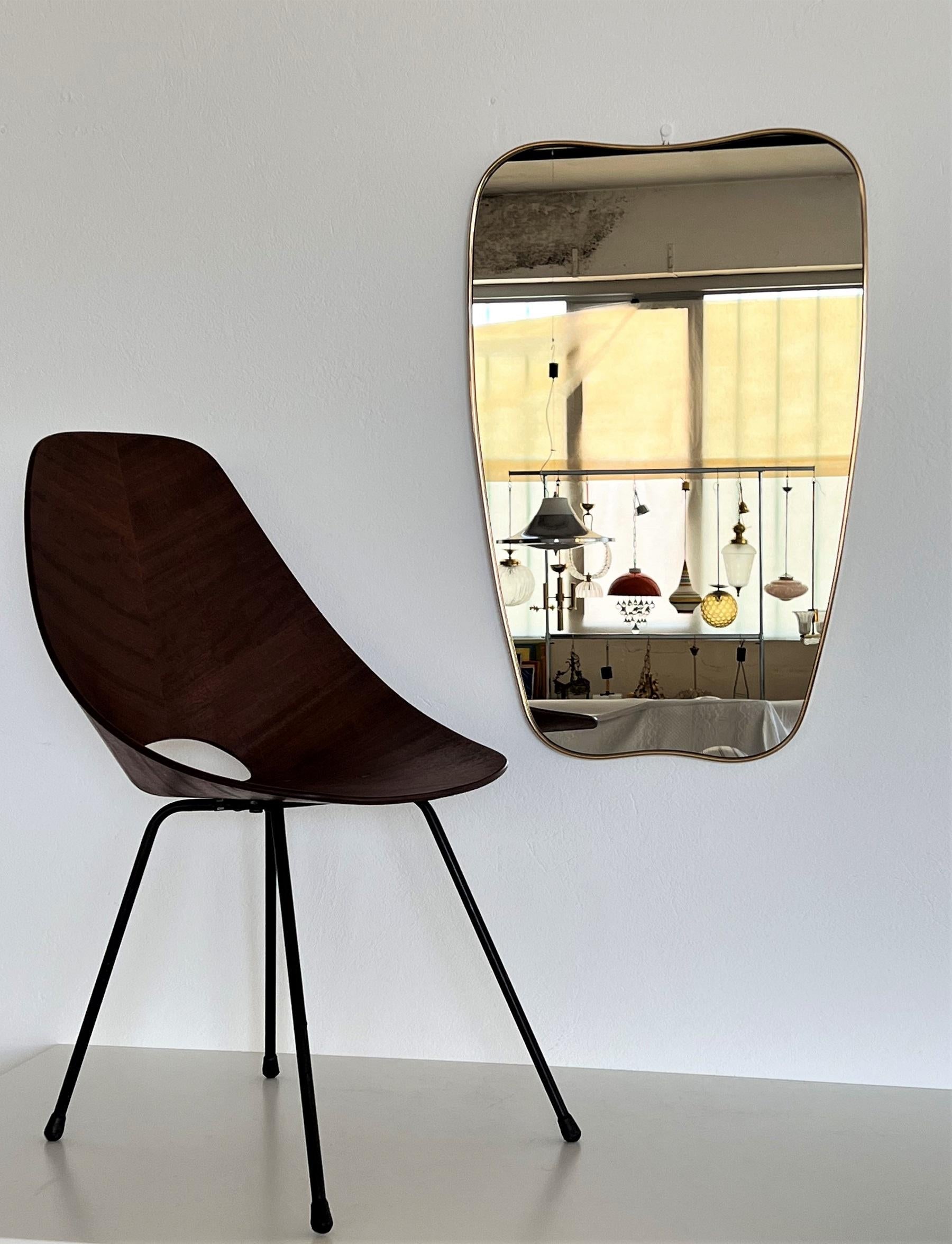 Beautiful and elegant, large vintage wall mirror with solid shiny brass frame and crystal mirror glass.
Made in Italy in the 1970s. Reminds to the model by Giò Ponti.
The brass frame was polished and therefore is in very nice shiny condition. 
The