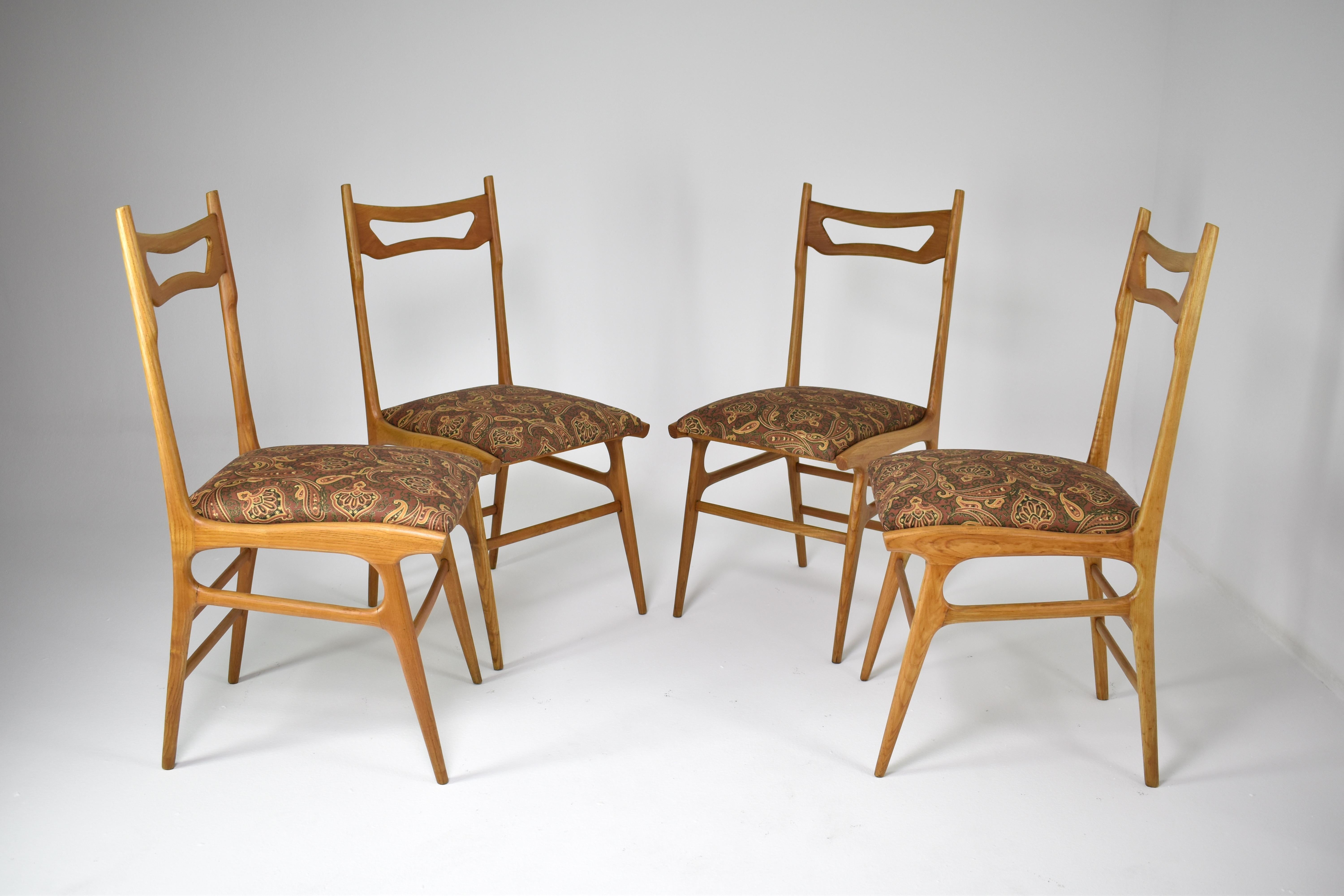 A set of four remarkable Italian dining chairs from the 1950s, each adorned with original upholstery that boasts a fantastic vintage pattern. These chairs feature the original upholstery on the seat and, have two panels on the top, which have been