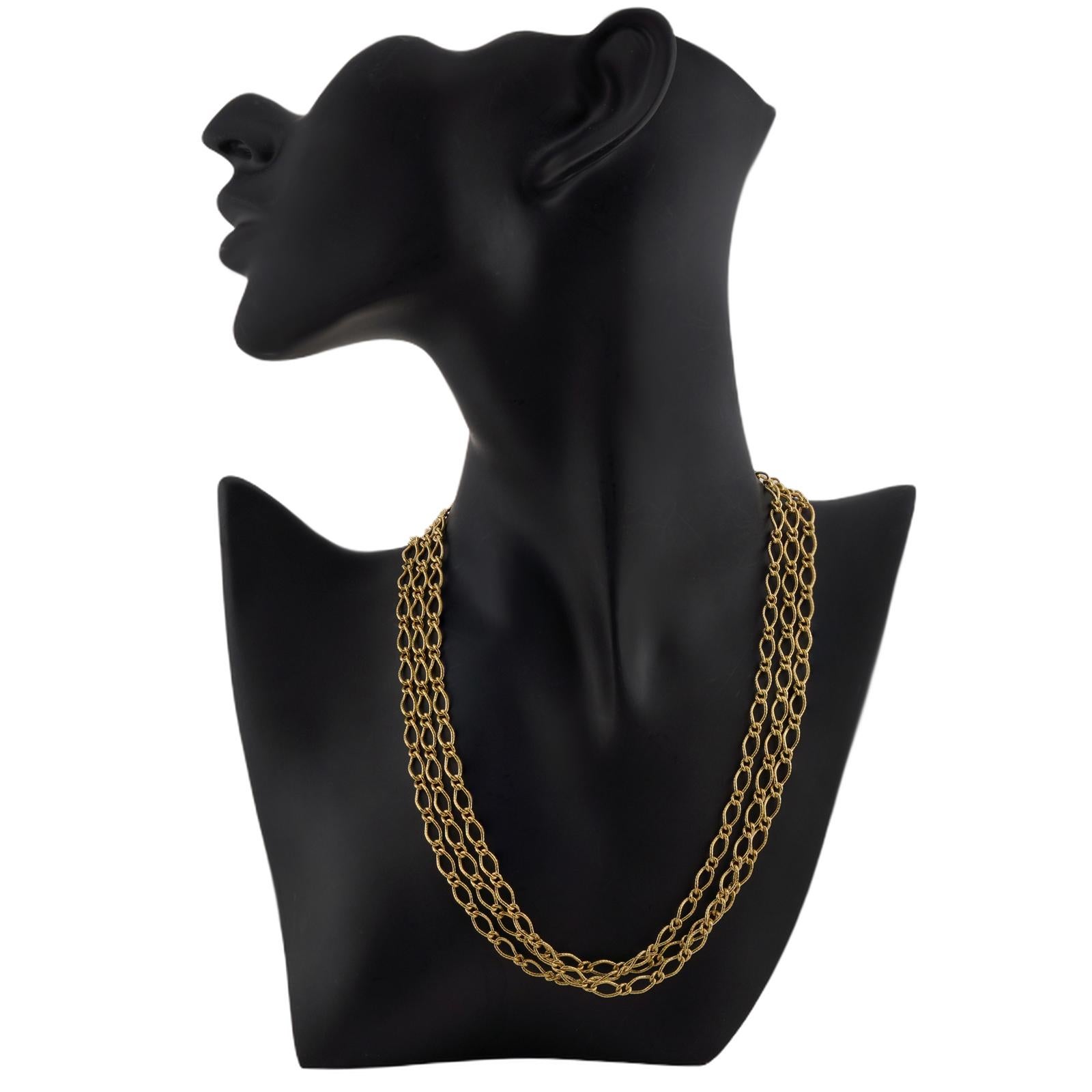 Questa classica collana unisex lunga a tre file presenta un design a catena realizzato in oro giallo 18 carati. Realizzato in Italia intorno agli anni '1990. Misure: Lunghezza 17