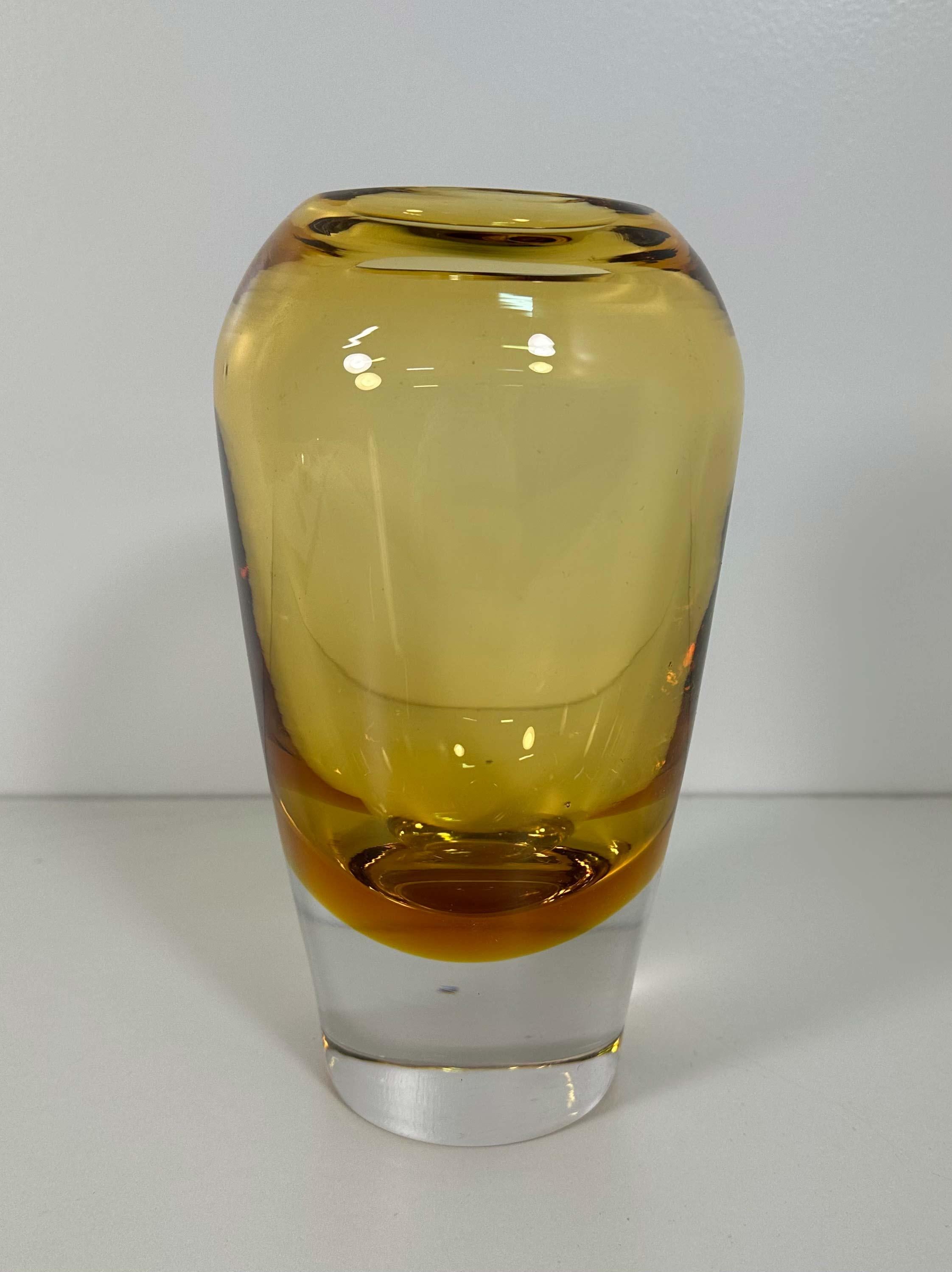 This Vase was produced in Murano, Italy in the 1970s
It is made with a particular glass working technique called 'sommerso', which means made with different color layers: a yellow and a transparent one. 
In very good vintage conditions.