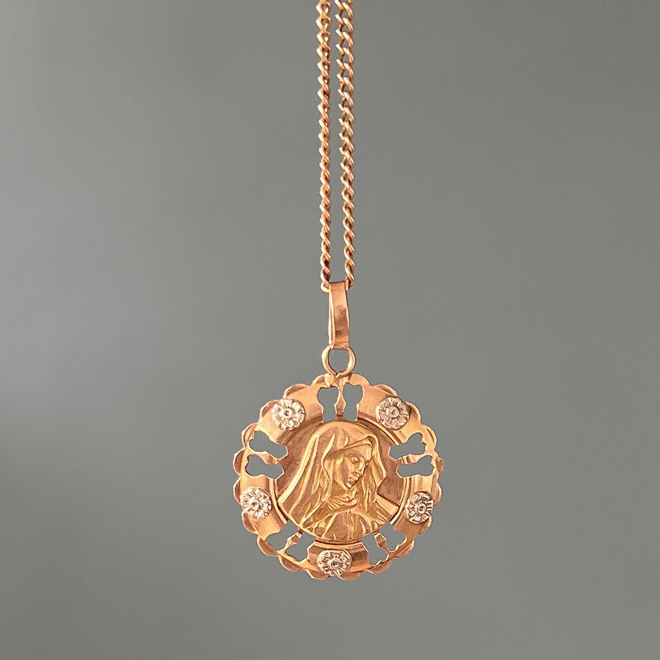 A vintage Italian 18 karat gold and silver Virgin Mary pendant. This pendant is beautifully created with an openwork border set with floral decor of five silver flowers and in its center Virgin Mary is depicted in high relief. 

Charms and pendants
