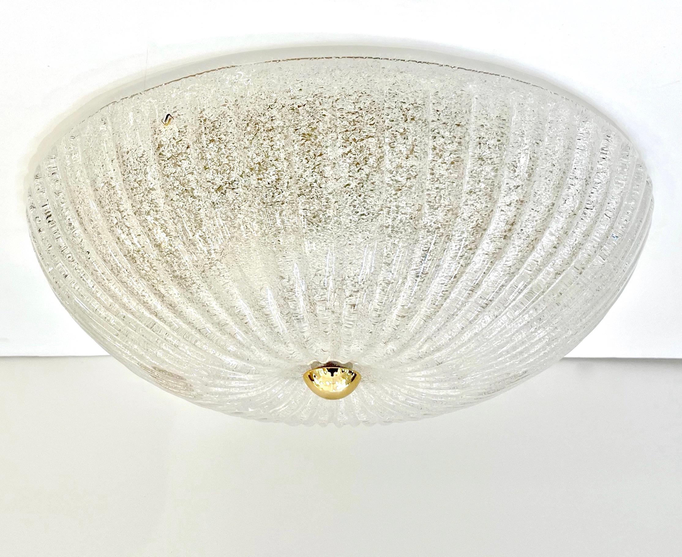 A pair is available - A contemporary Mid-Century Modern style crystal clear Murano glass flush mount or wall light, entirely handcrafted in Italy, the reeded glass bowl blown on the Murano island, signed Vistosi, is elegantly frosted with