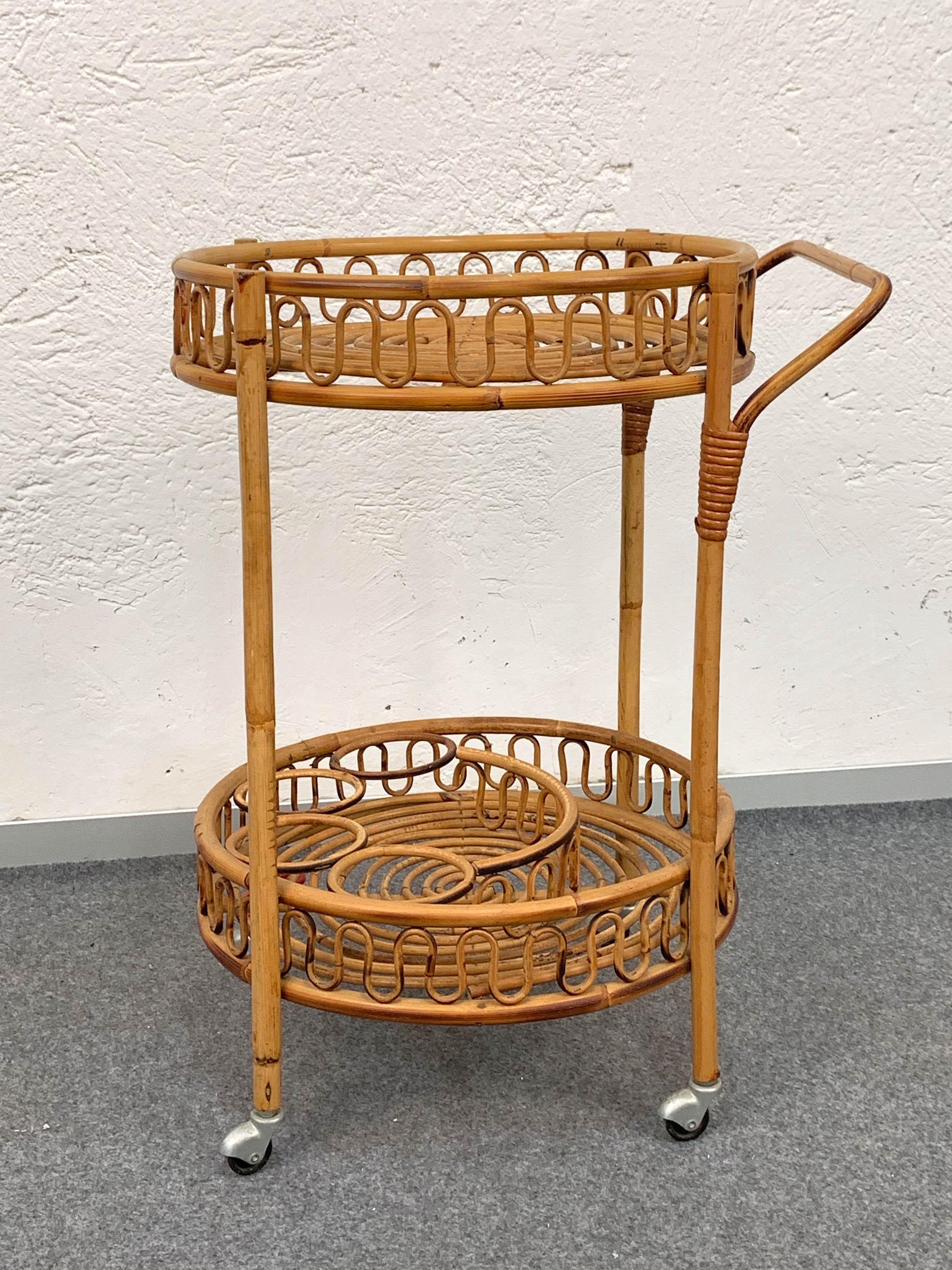 Fabulous midcentury bar cart from the 1960s in perfect conditions.

It is made in bamboo, it has two levels and two large wheels at the base. The lower level has a bottle rack on the back.

Perfect for a midcentury bar project or a stylish