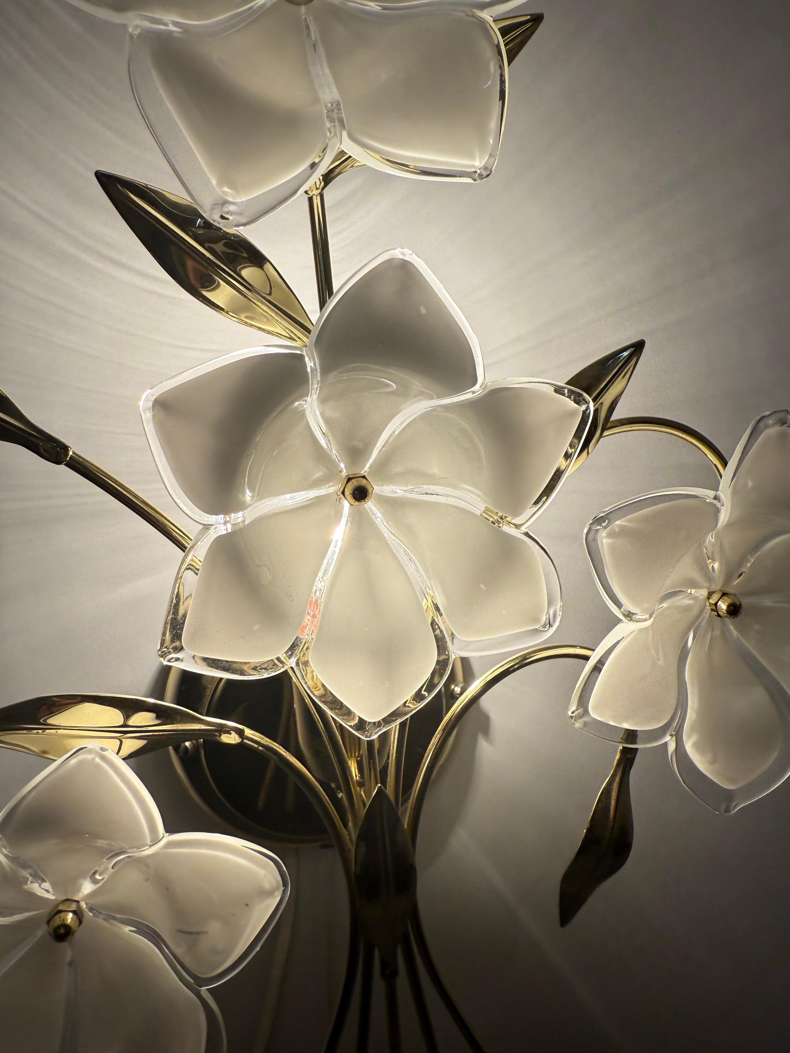 This beautiful set of two wall lights captivates with its vintage charm. The beautiful glass was hand-shaped by master glassblowers into beautiful glass blossoms, making each glass blossom unique. The gold-colored metal frame with leaves enhances