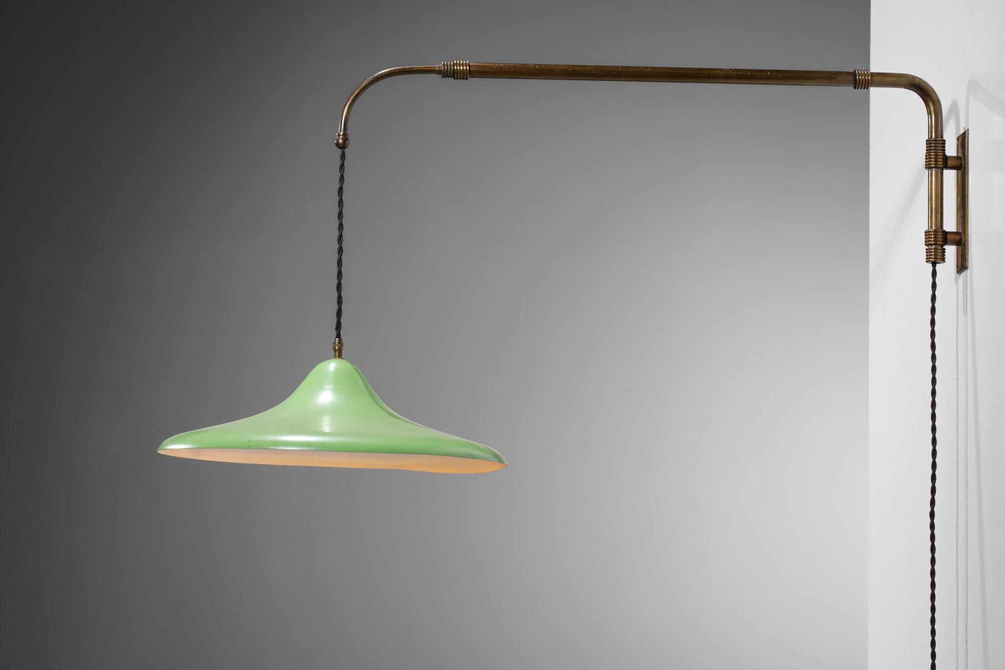 Italian telescopic bracket from the 50's in the style of Arredoluce's work. Structure and counterweight in solid brass, shade in almond green lacquered metal. Counterweight and pulley to modulate the height of the diffuser and the length of the stem
