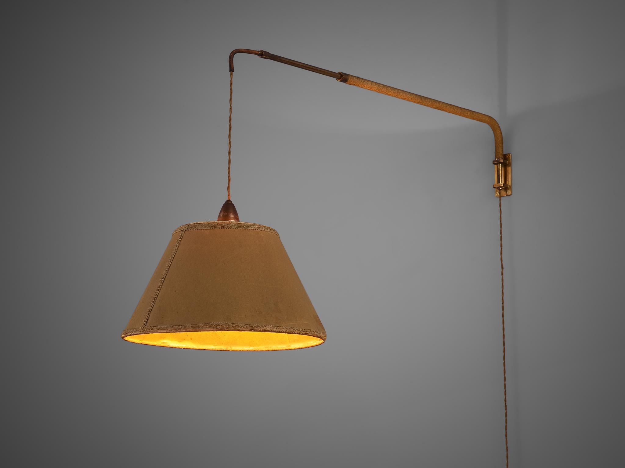 Wall light, brass, brass and rope, Italy, 1960s. 

Very elegant wall light with an inventive adjustable mechanic. The light is attached to the wall by an extendable brass tube, which is finished with rope. Through this tube goes the wire of the