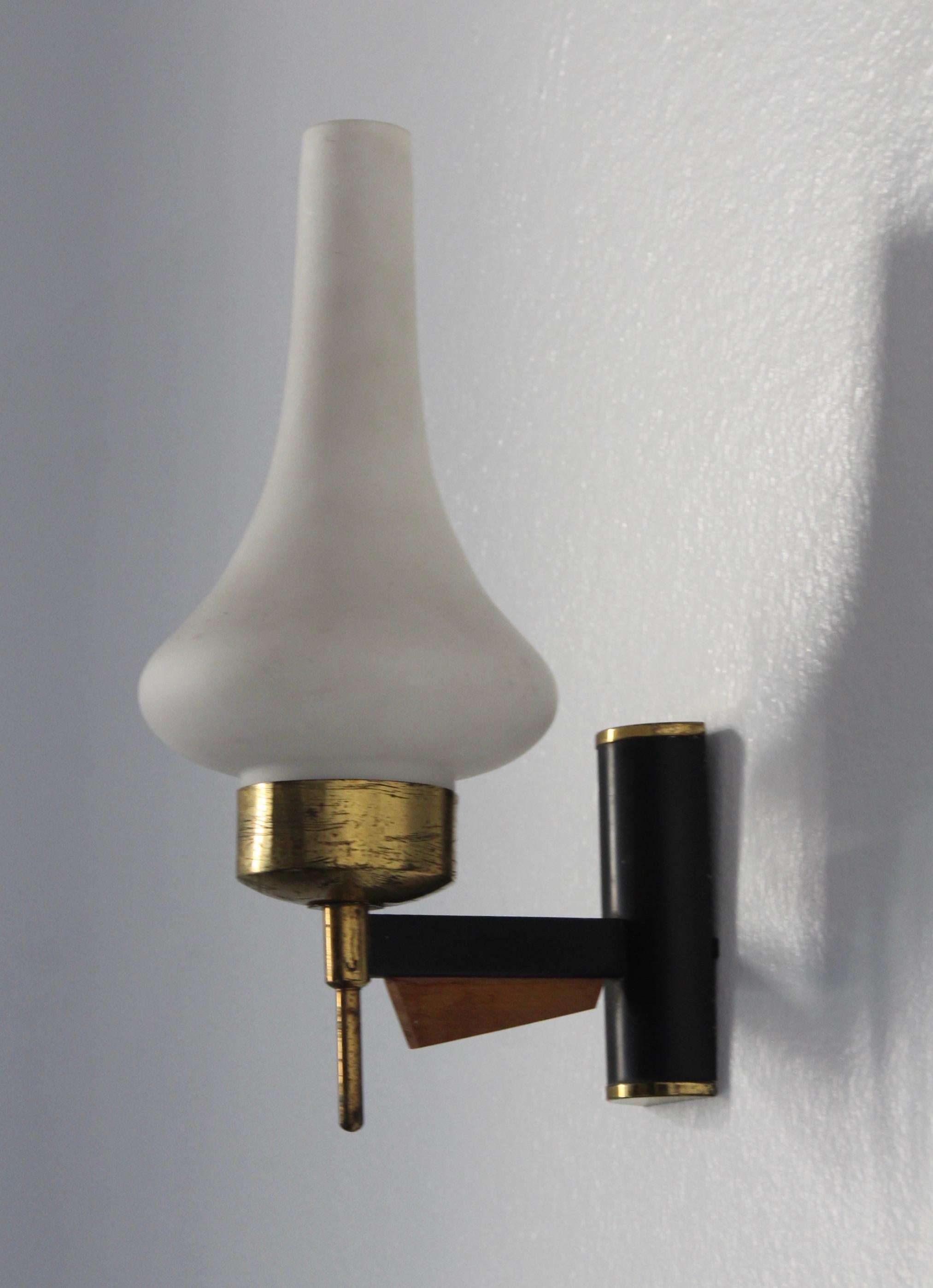 A pair of wall light / sconces. Designed and produced in Italy, 1950s. Features brass, black-lacquered metal, teak, and Milk Glass.

Lights presents with beautiful all original patina.

Measurement doesn't include bulbs. Fixture needs to be