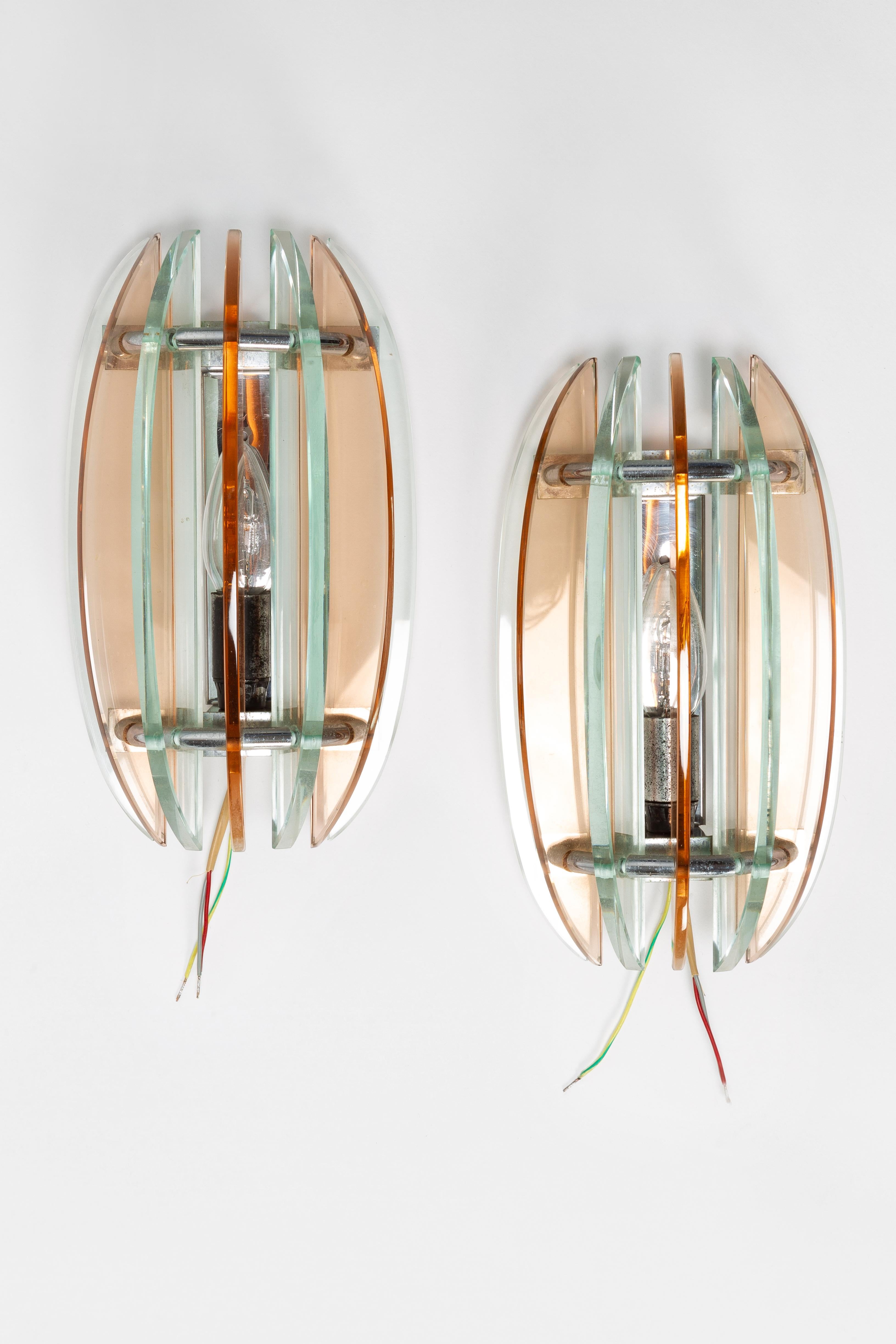 Wall lights manufactured by Veca in the 1960s in Italy. Two wall lights with seven alternating clear and smoked glass pieces on a chrome steel frame. Newly wired.