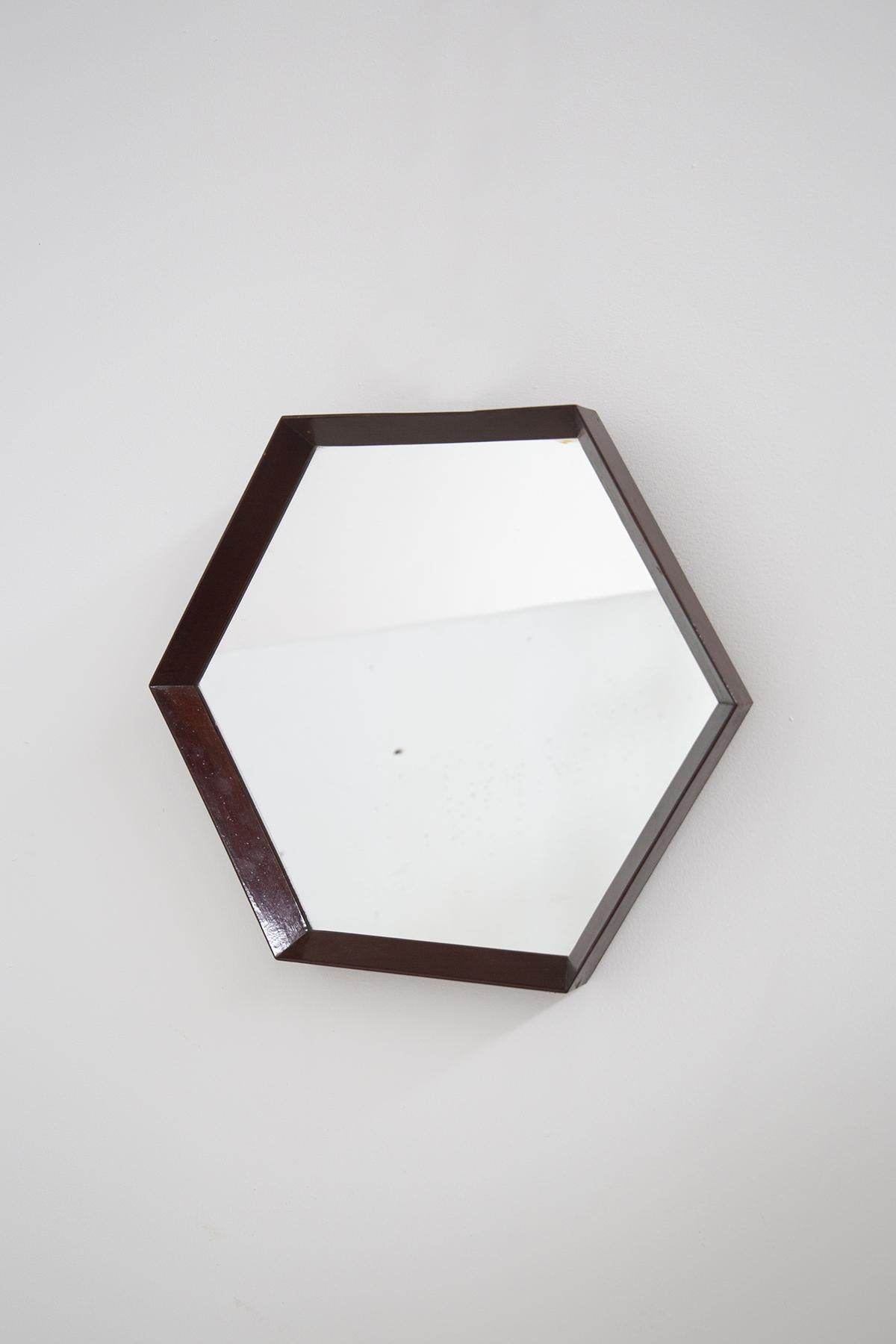 Italian wall mirror by Campo and Carlo Graffi from 1960. The mirror is made with a hexagonal shaped wooden border and inside mirrored glass. The mirror is ideal for entryways or living rooms or over a console table. 
Light scratches from wear and