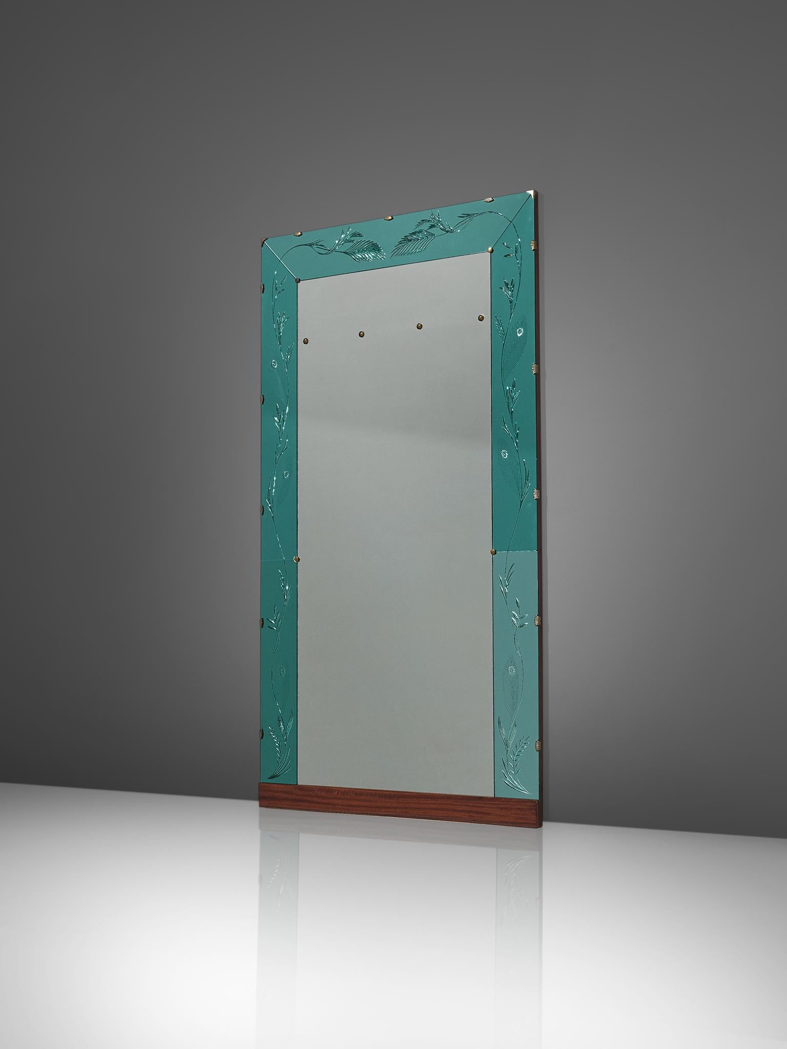 Wall mounted mirror, glass, brass, mahogany, walnut, Italy, 1950s.

An elegant Italian wall-mounted mirror in two tones. The mirror is framed by a turquoise glass frame, supported by brass elements. The turquoise glass frame is engraved with