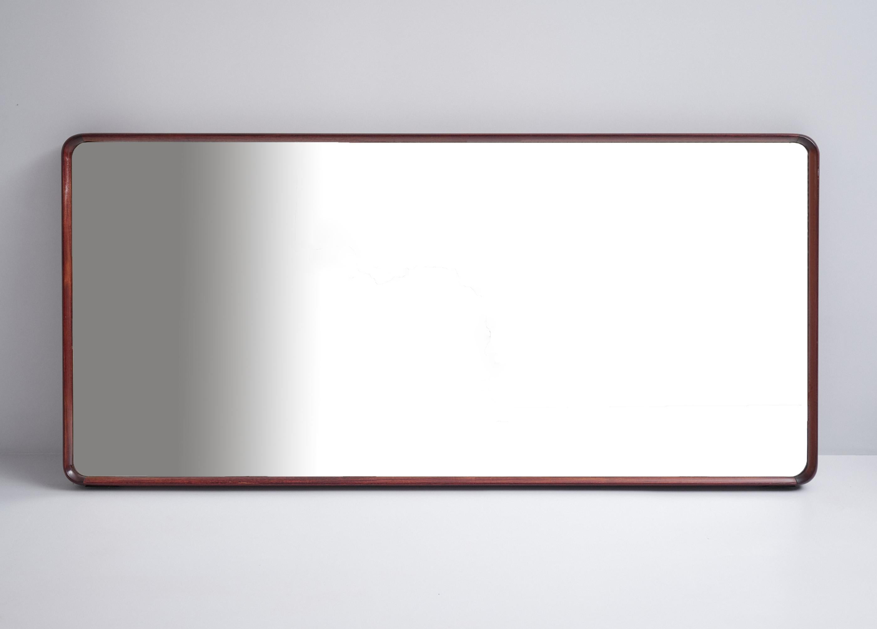 Large wall mirror of Italian production and design from the 1950s

Made of milled dark solid wood, with rounded frame

Elegant and modern, original patina, pleasant signs of aging on the mirrored glass.

This mirror can also be hung upright