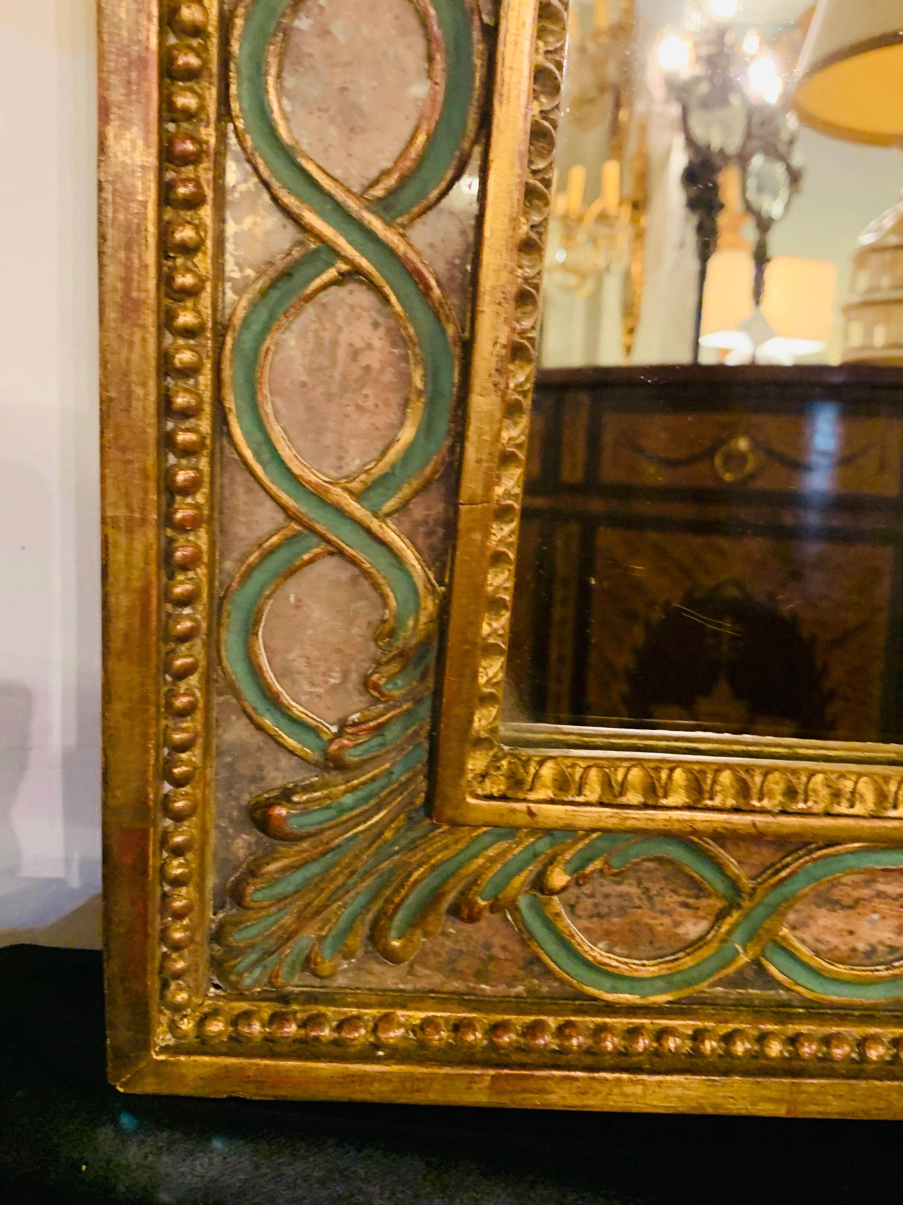 Italian wall or vanity mirror with antiqued giltwood and hand painted frame
This exquisite midcentury Italian mirror has a beautiful frame featuring antiqued mirror panel and hand carved giltwood finely painted in green. The mirror can be used as a