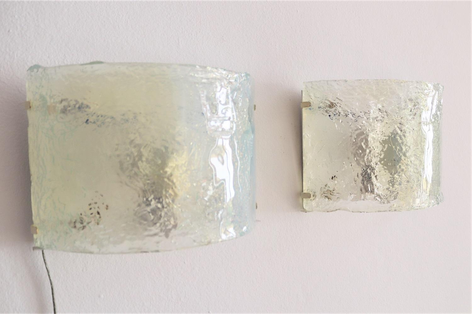 Beautiful set of two wall sconces made of gorgeous curved opaline Murano glass and white metal wall bracket.
Designed by Carlo Nason and manufactures by Mazzega.
Made in Italy during the 1970s.
The opalescent glasses leave a magical impression, as