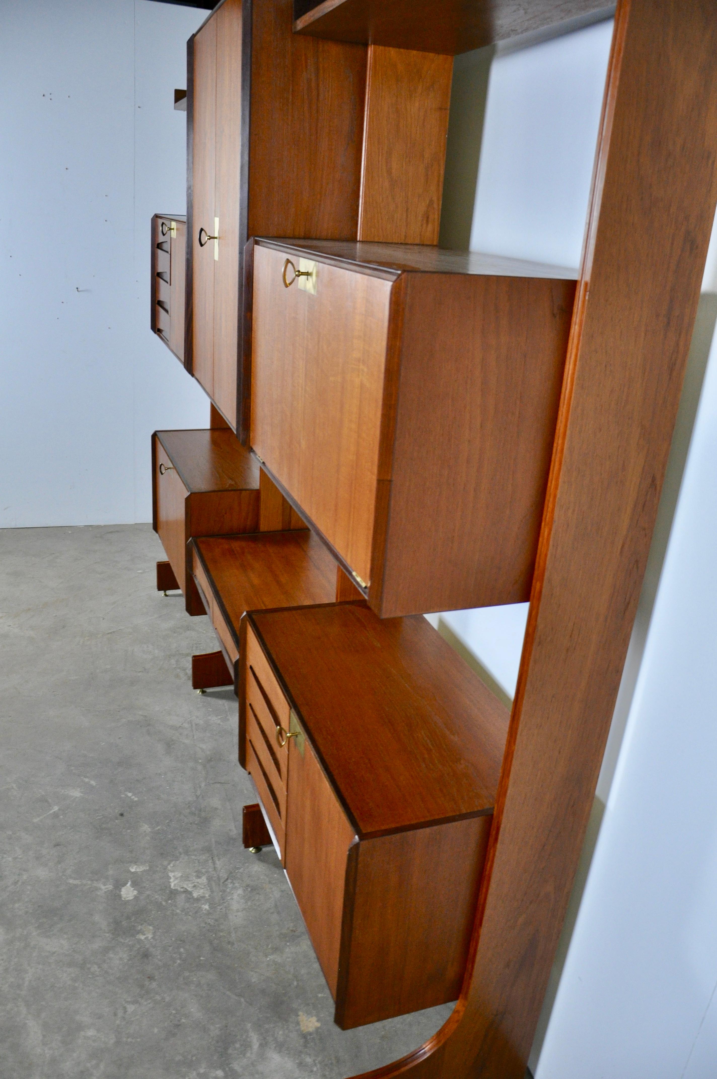 Wall unit composed of 2 boxes with hinged doors, 2 boxes with 4 drawers and a door. 1 box with 2 drawers, 1 box with 2 doors and 3 storage boards, 4 boards and 4 uprights. Brass lock with keys.