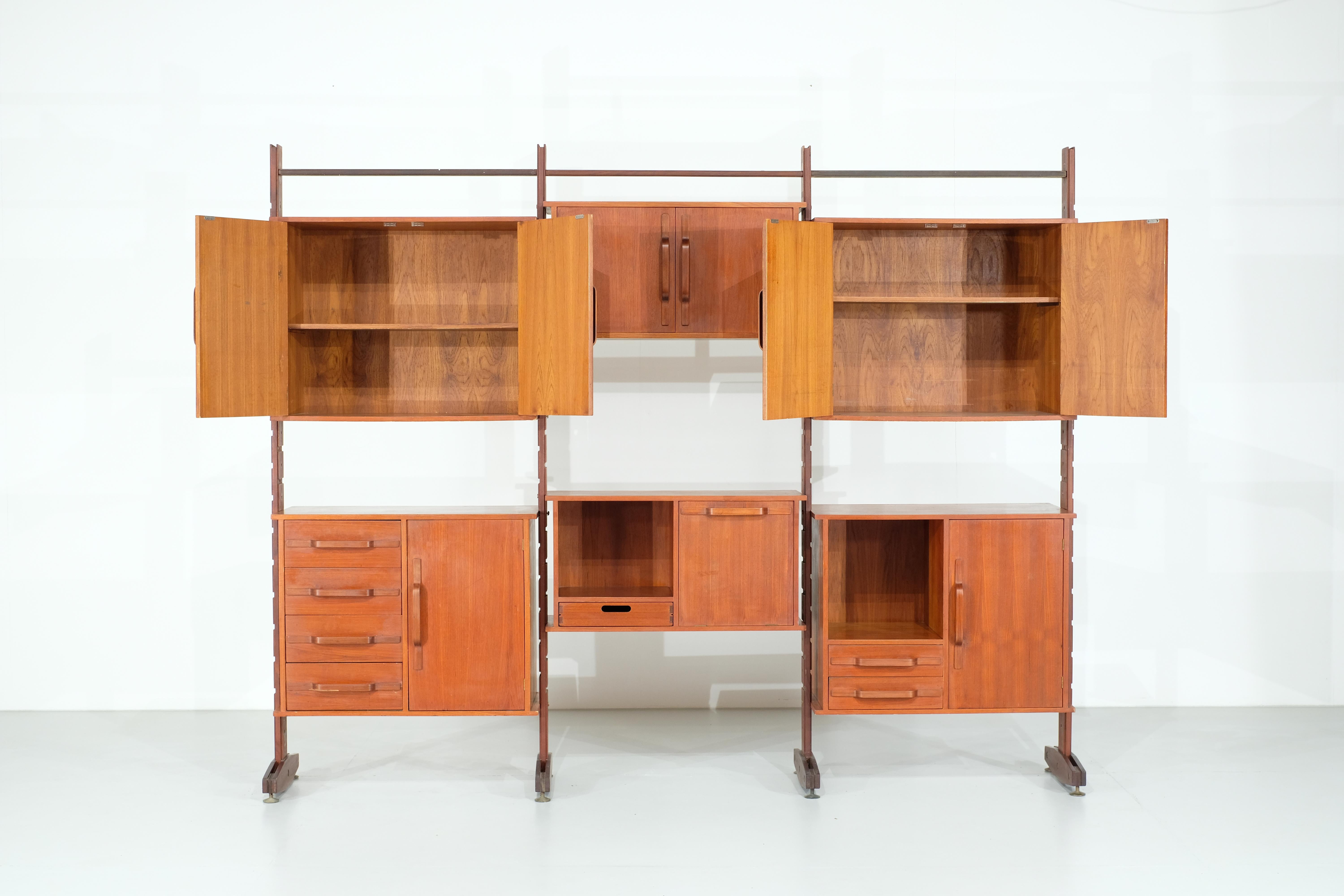 Superba parete attrezzata italiana progettata negli anni '60. È realizzato interamente in teak.
È composto da sei scomparti di dimensioni diverse, che ti permettono di avere un ampio spazio di archiviazione.

Ogni scomparto è dotato di cassetti o