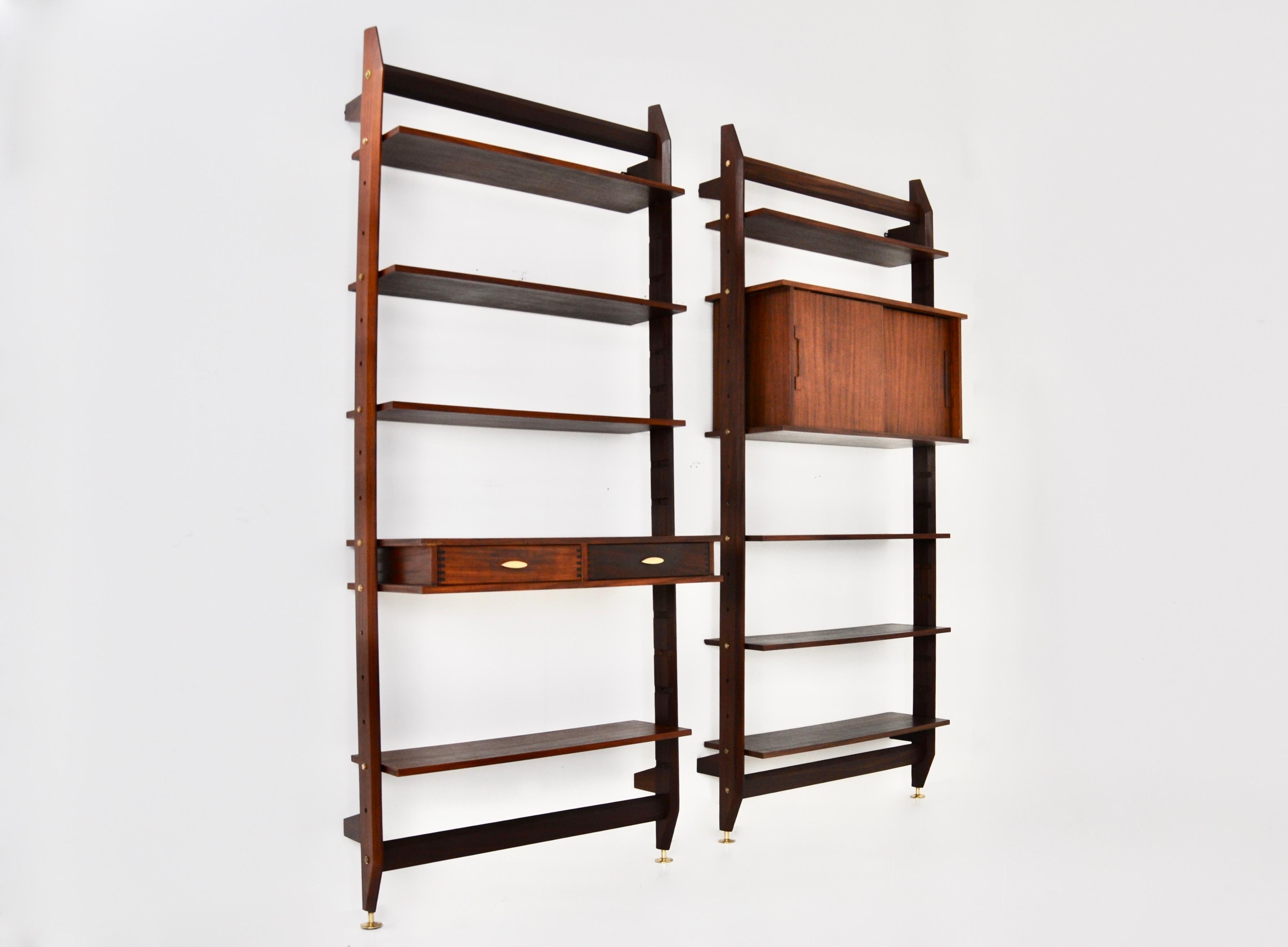 Set of 2 modular wall units in wood and brass consisting of 8 shelves and a double-door box containing 1 shelf and 1 box with 2 drawers. Wear due to time and age.