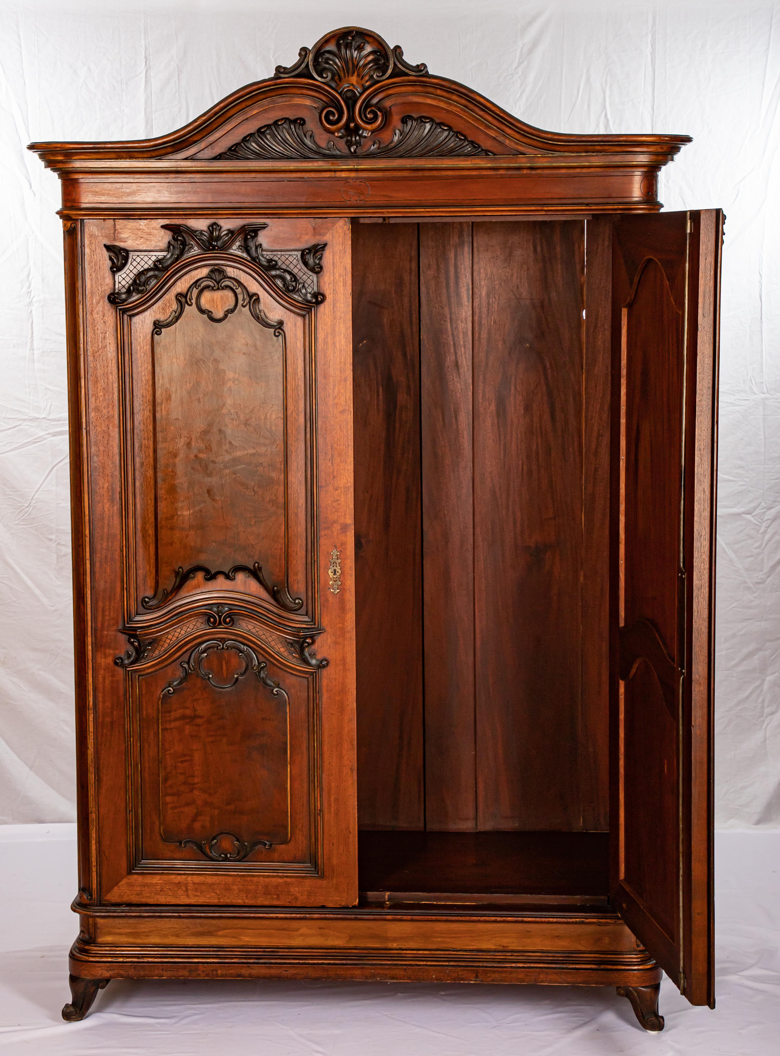Offering this magnificent Italian 2-door armoire. This armoire features gorgeous walnut wood that has been handcrafted and hand carved. This piece starts on the bottom on snail legs. Rising from there the beautiful hand carved doors are the next
