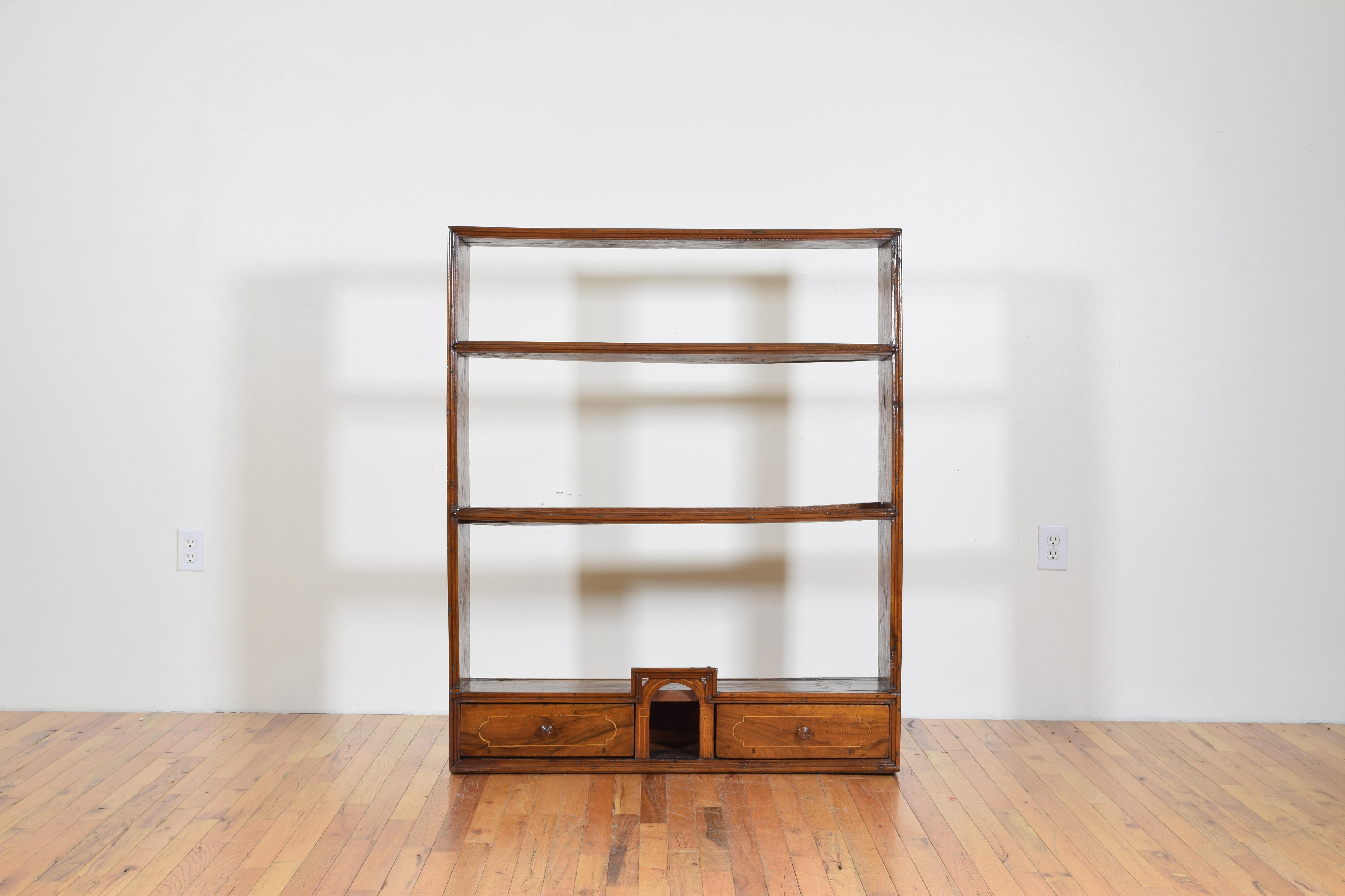 The frame with inlaid sides with a bottom storage section housing two inlaid drawers and a centred open section with over-arch, the shelves with plate rests.