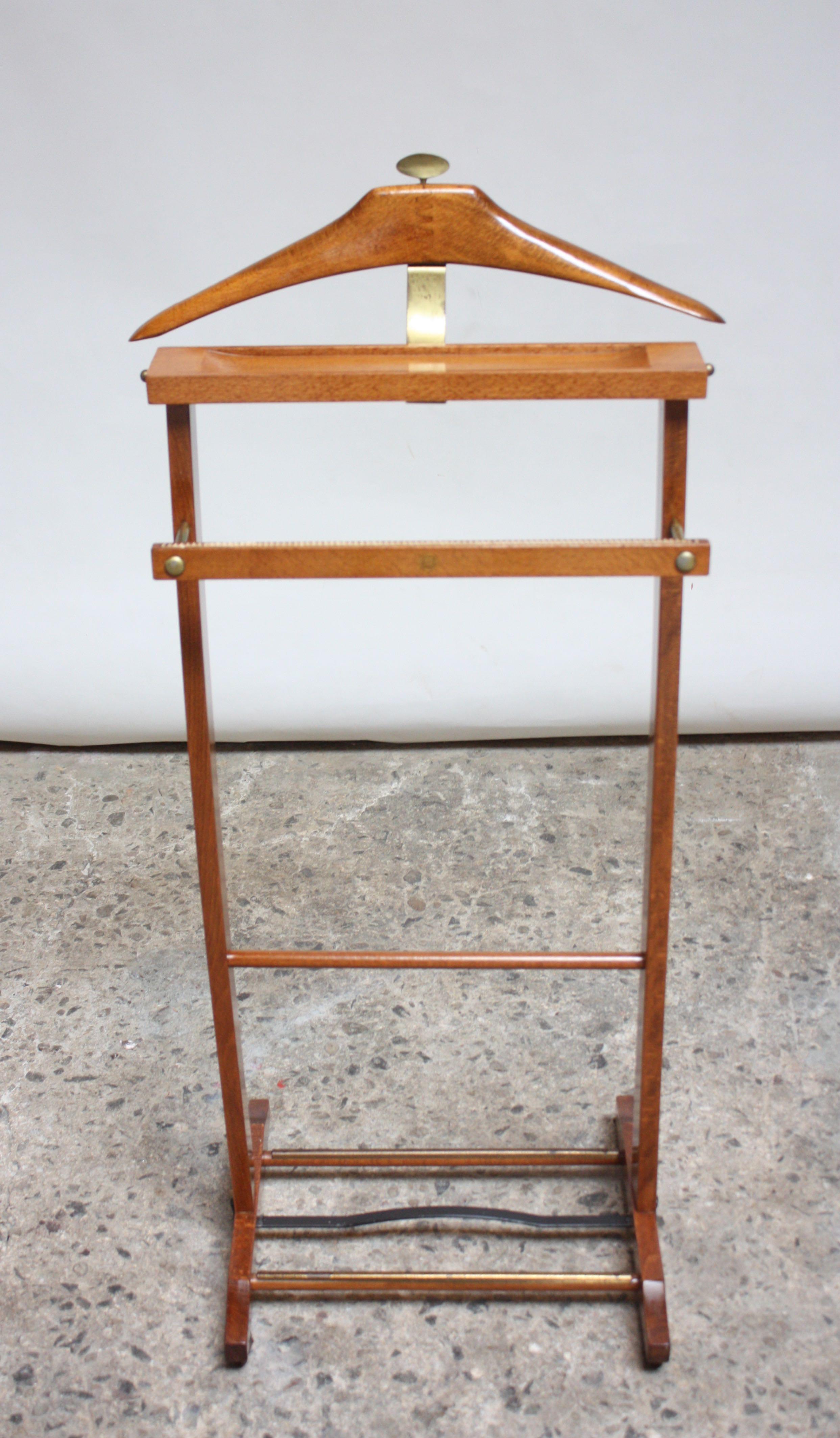 Uncommon Italian valet designed by Ico Parisi for Fratelli Reguitti in the 1950s. Composed of a hanger with brass accents and change or cufflink holder with a double rack on the bottom for shoes, lower bar (presumably for socks) and four caster