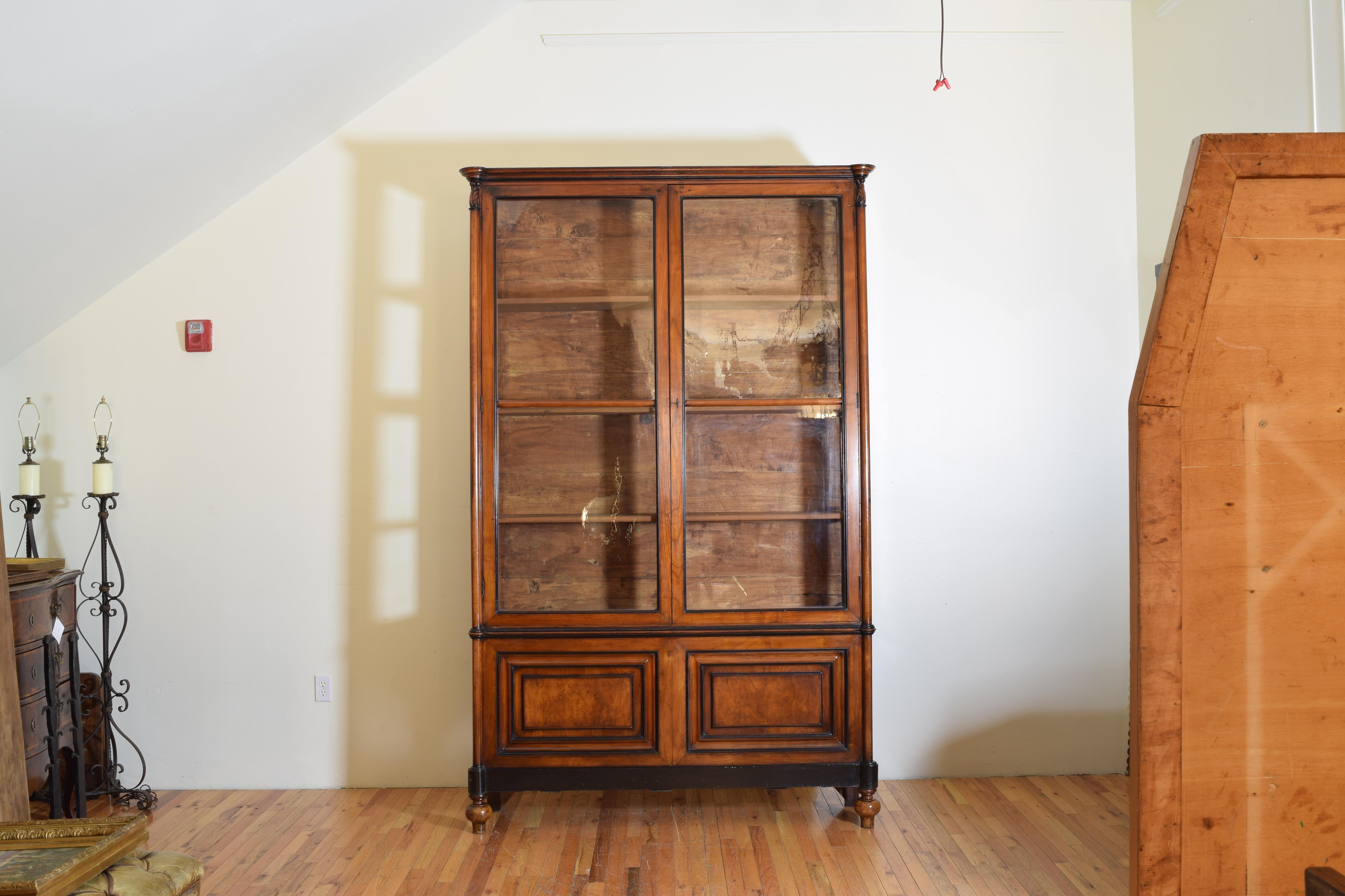 This unique cabinet is both tall and shallow and likely came from a retail shop of some sort, the upper portion has glass doors and glass sides allowing viewing of contents from all angles in the room, the outer sections of the doors are rounded as