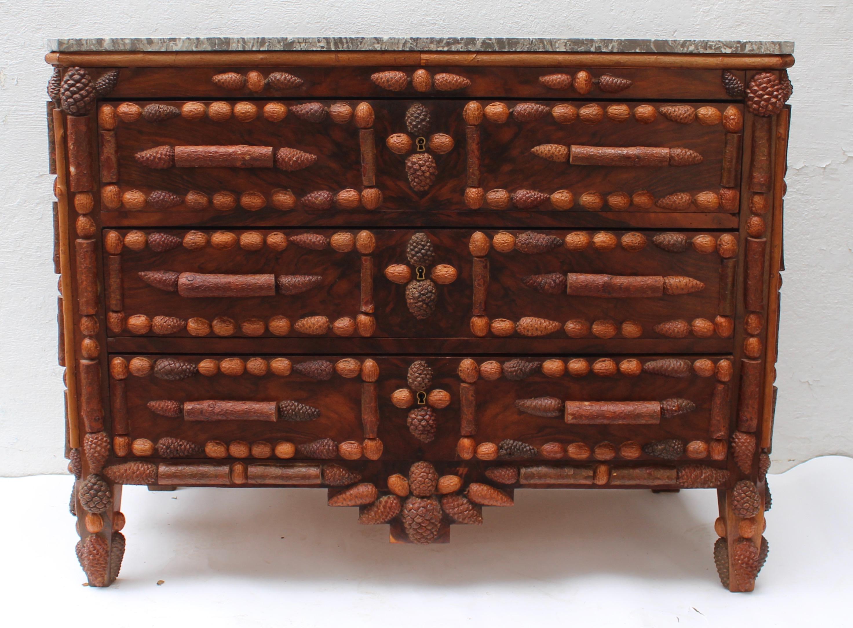 Italian walnut and pinecone decorated chest of drawers with marble top.