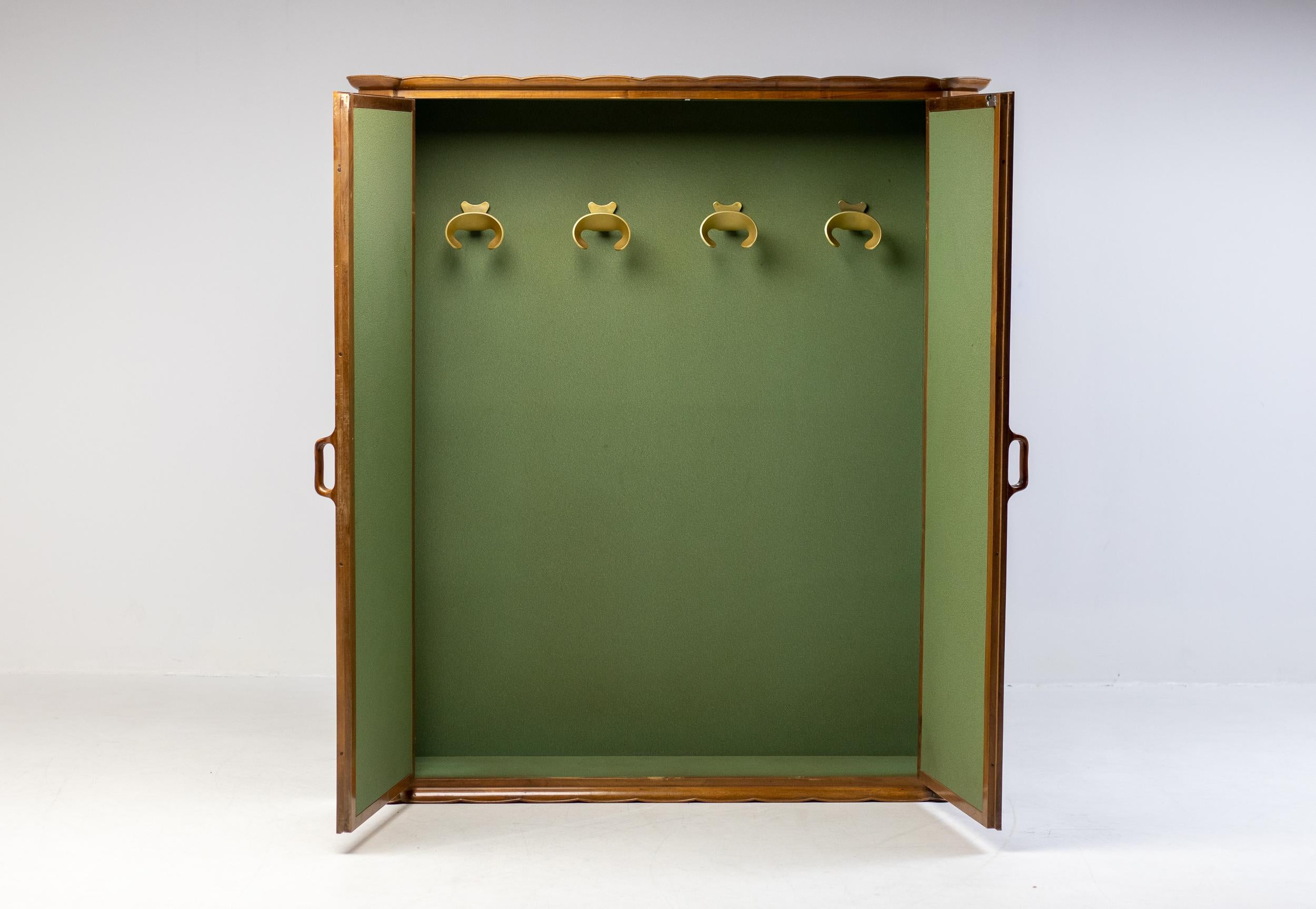 A superb Italian walnut wardobe covered with green felt on the inside, made to Measure for the villa of an Italian executive in 1960. Inside the wardrobe 4 organic design coat hangers in cast bronze are mounted to the rear panel. The wardrobe