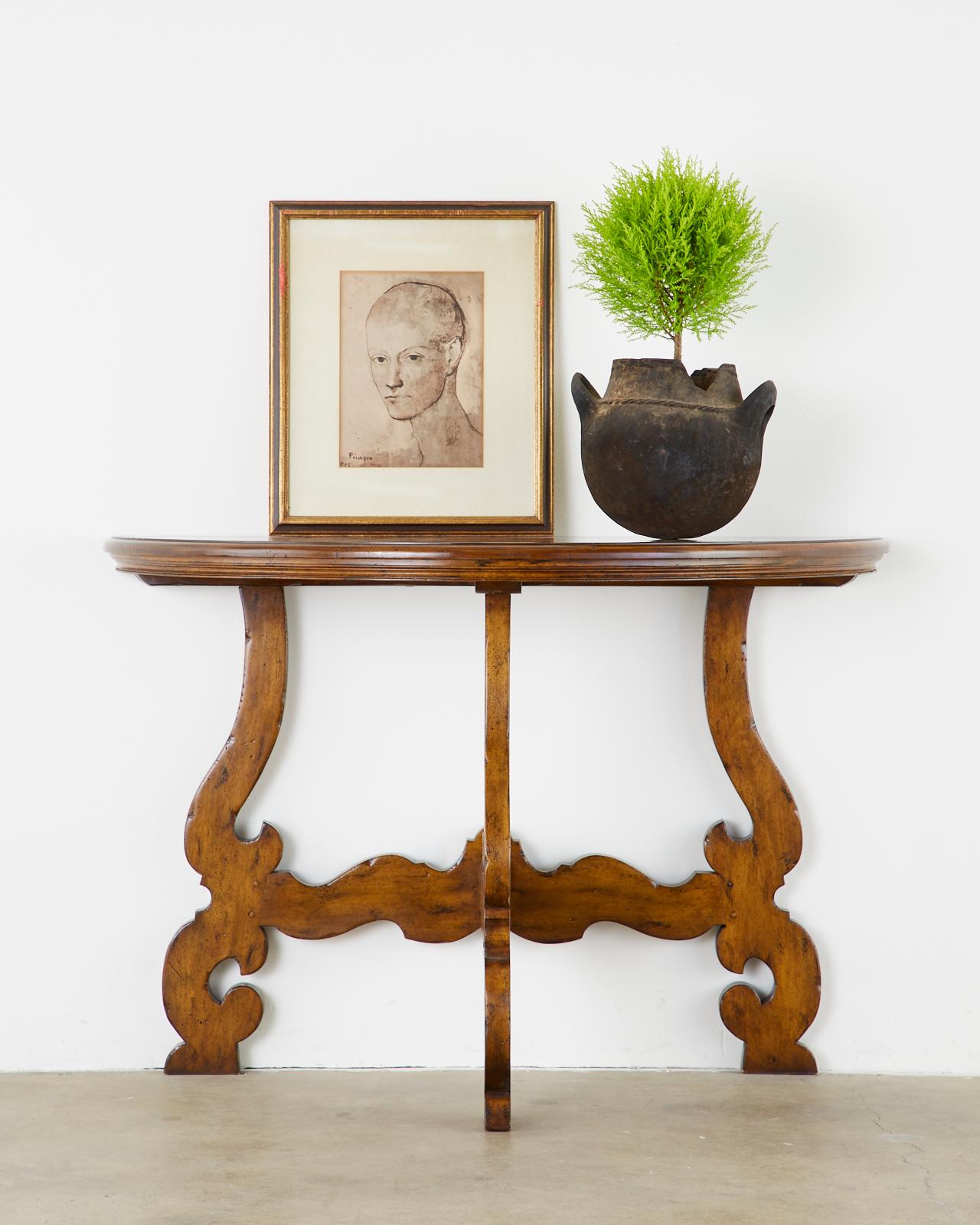 Handcrafted Italian walnut demilune console table constructed from walnut. Beautifully finished with an intentionally aged and distressed finish. The tripod leg base has mortise and Tenon joinery with scrolled shapes. Made from 1.25 inches thick