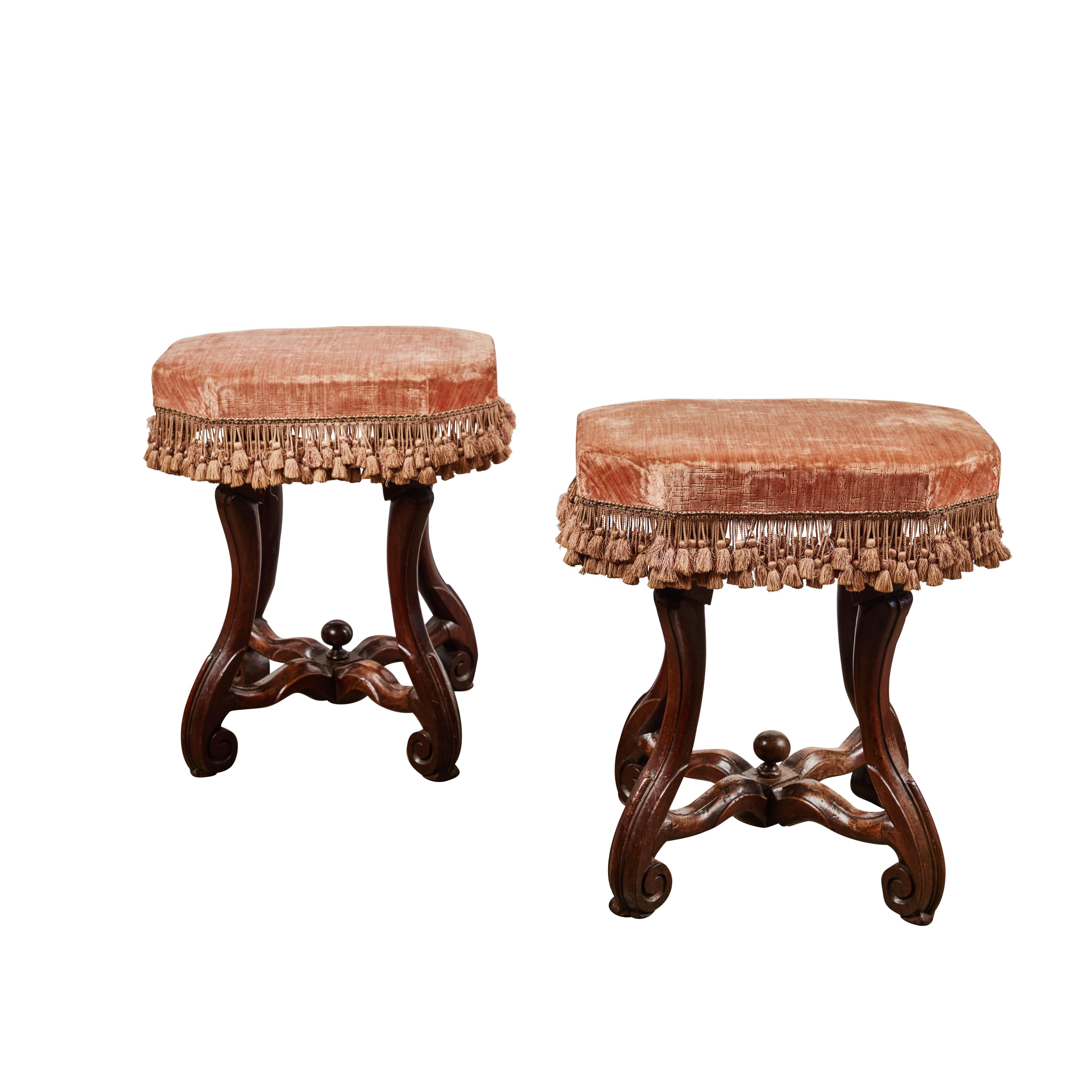 Pair of hand carved walnut rectangular shaped benches. Covered in later silk velvet fabric and fringe. The scroll legs give elegance to these benches.