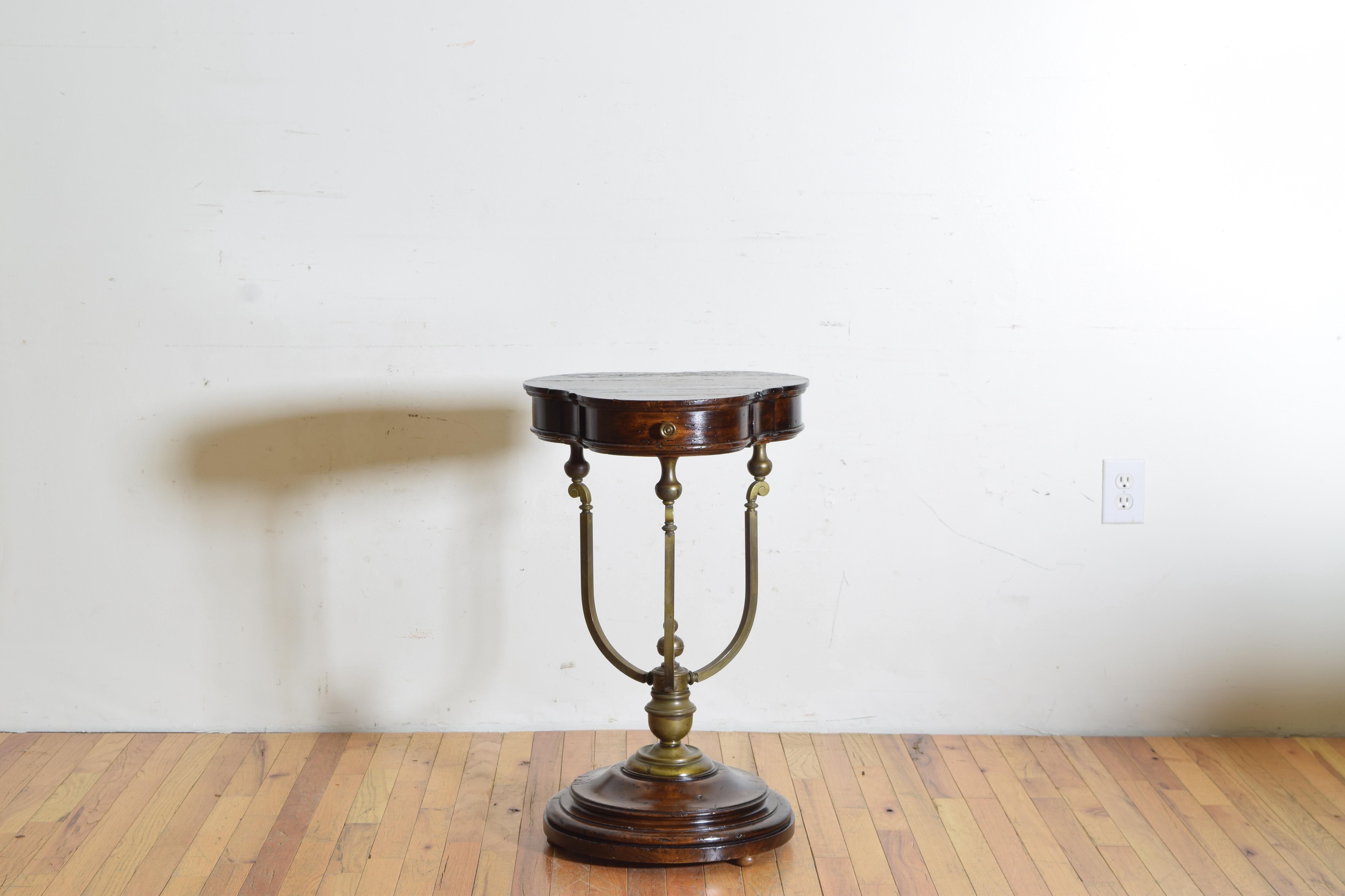 This very unique table, likely Milanese, has a trefoil shaped top and three drawers with brass pulls, raised on cast brass supports atop a plinth-form circular base.