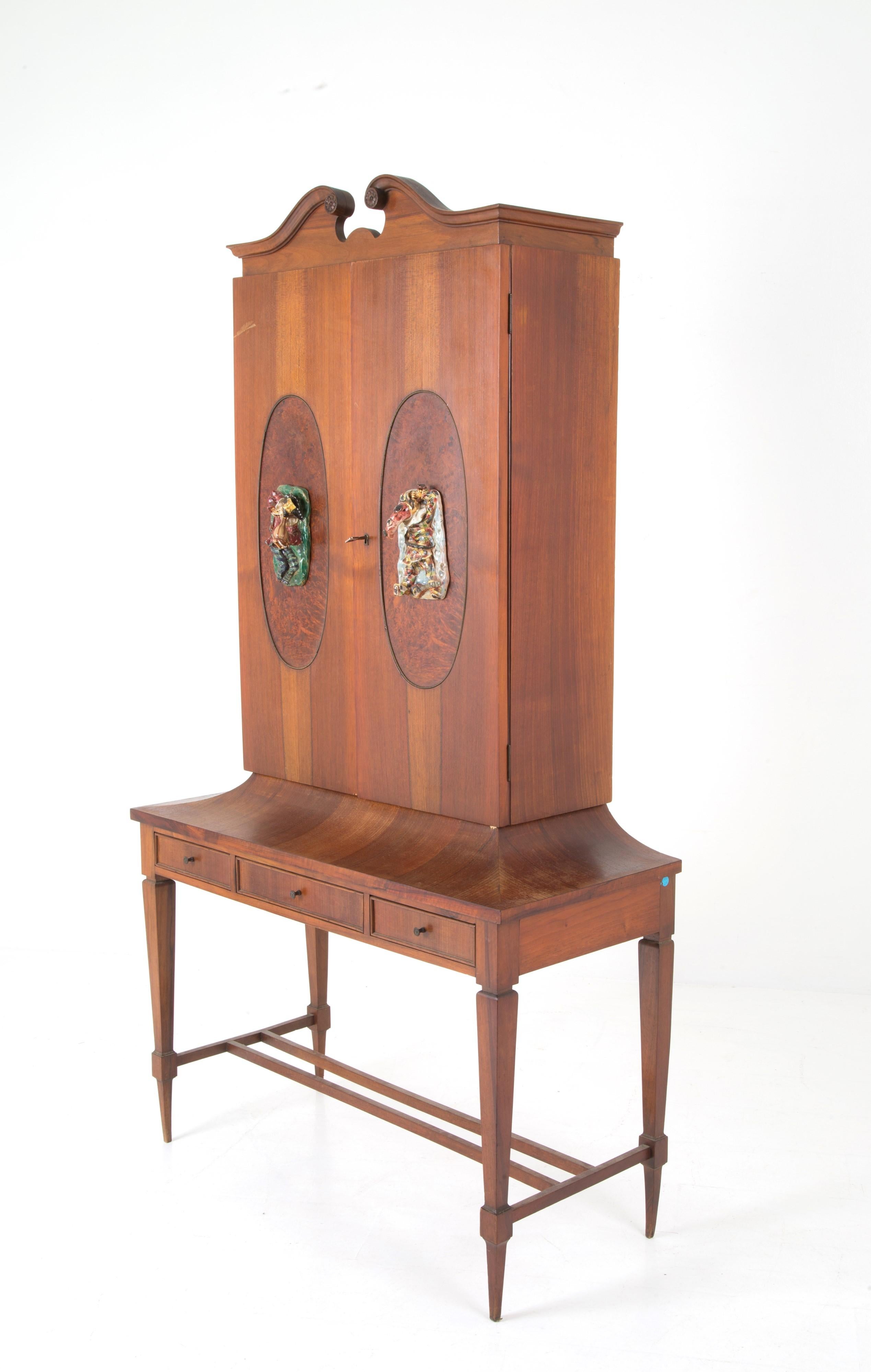 Mobile d'epoca impiallacciato in legno di noce e inserti ovali in betulla nello stile di Gio Ponti, con gambe affusolate e due sculture in ceramica di San Polo raffiguranti Pulcinella e Arlecchino realizzate da OTELLO ROSA come maniglie, realizzato