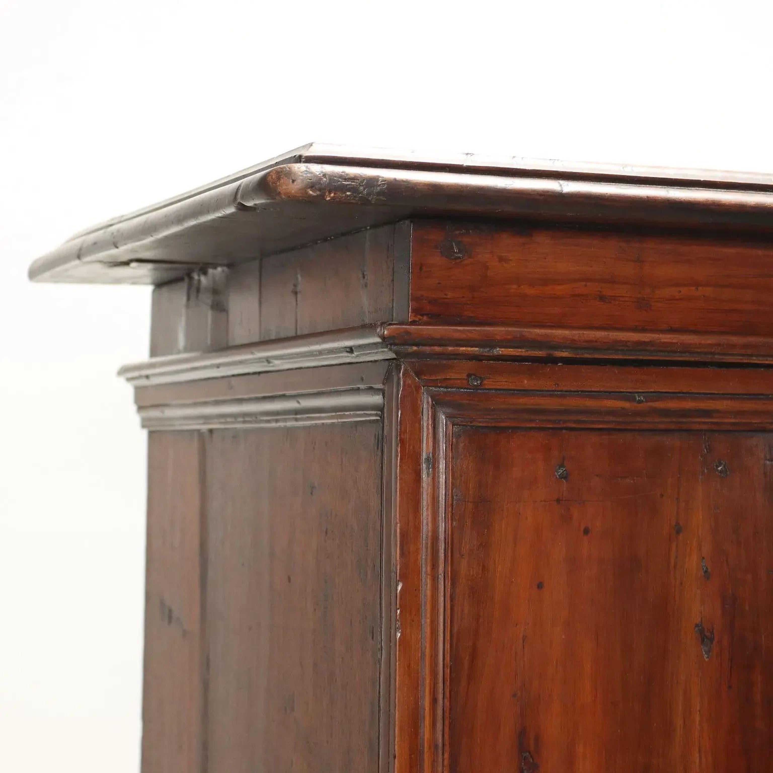 Rectangular top with molded edge over a pair of paneled doors raised on molded base with bracket feet 