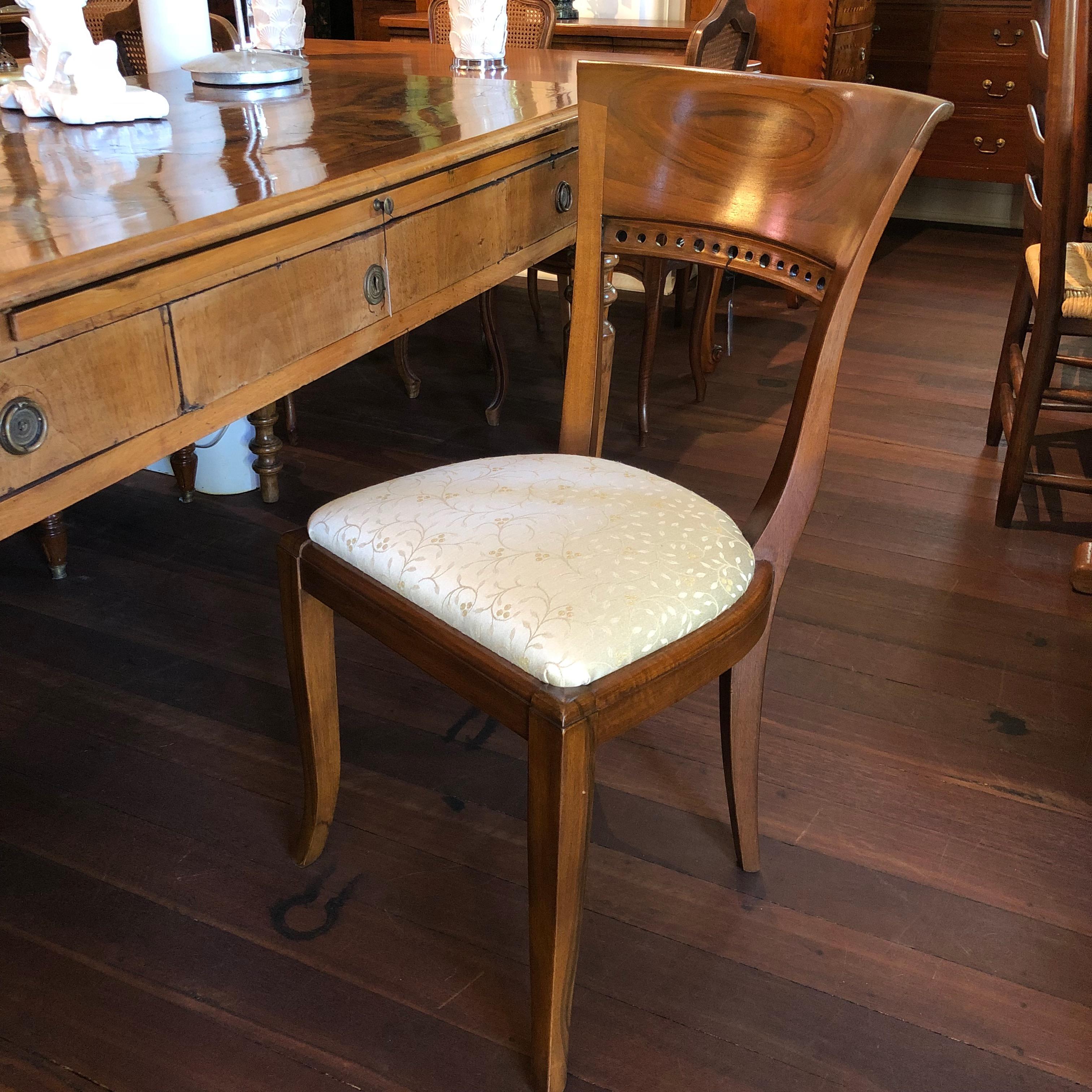 This beautiful circa 1920 occasional chair was found in Italy and has been crafted from Italian walnut and reupholstered with luxurious, ivory silk at a letter date. Slightly curved legs and back-bones lead up to a spectacular deco styled abstract