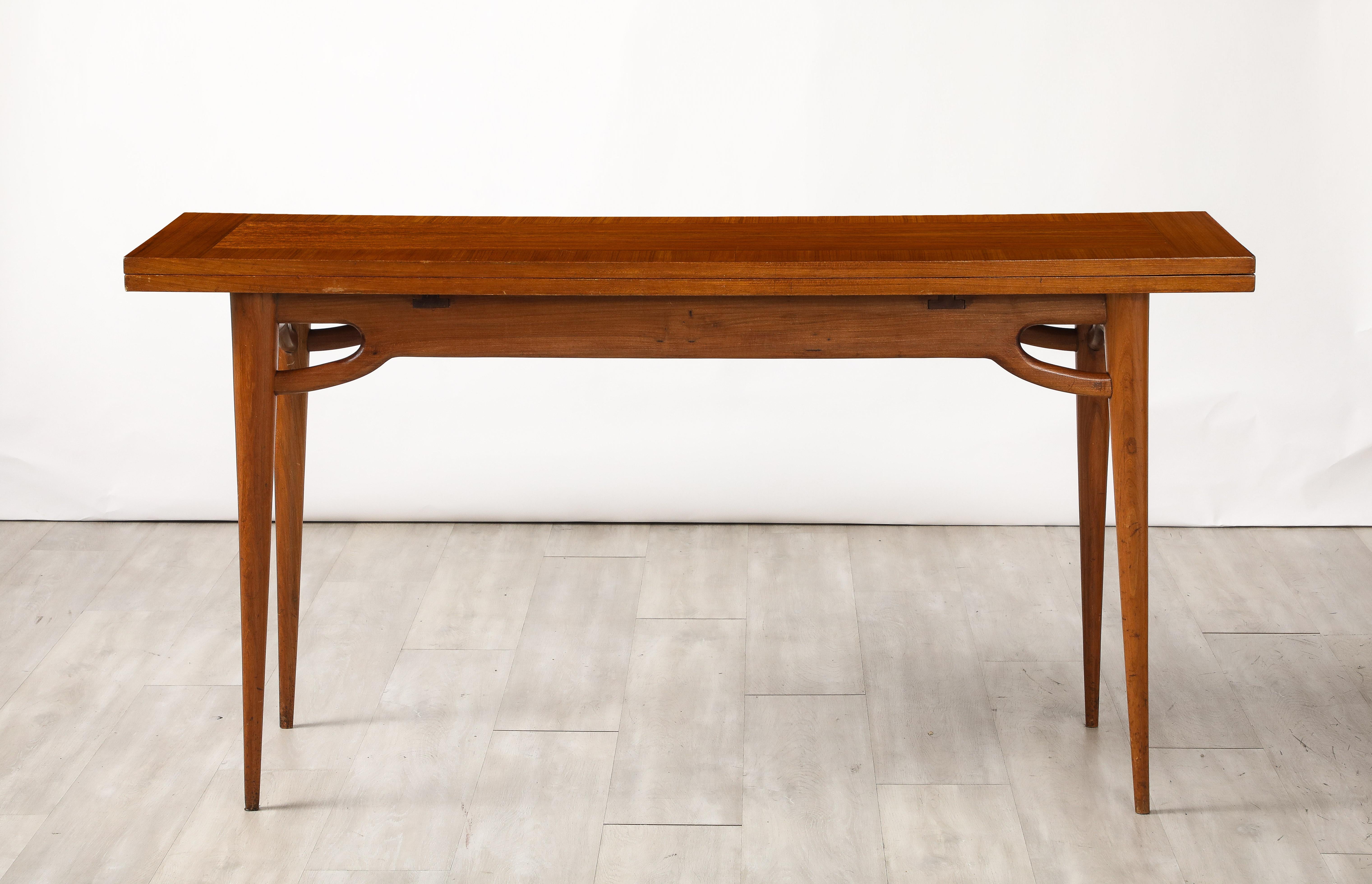 An Italian walnut flip-top console table with elegantly carved apron and tapered legs, with a rectangular top which opens to create a card or dining table.  Fantastic modernist design, highly unique and practical for multi-use. 
Northern Italy,