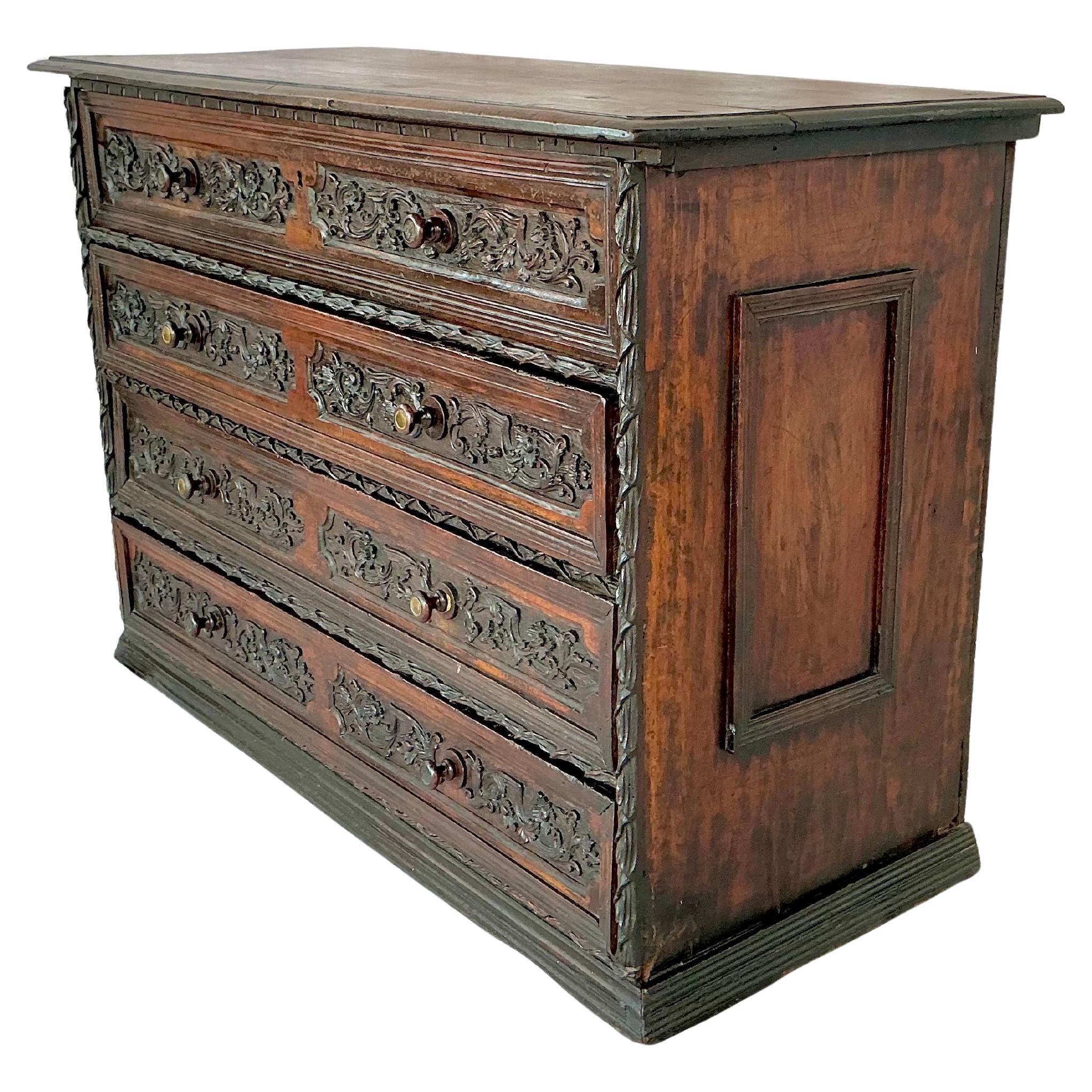 Early 18th Century Italian Carved Walnut Commode. Commode features four deep drawers adorned with elaborately carved foliate and scrolled motifs. The drawer faces are framed with deeply recessed molding and decorated with bold, high-relief carving