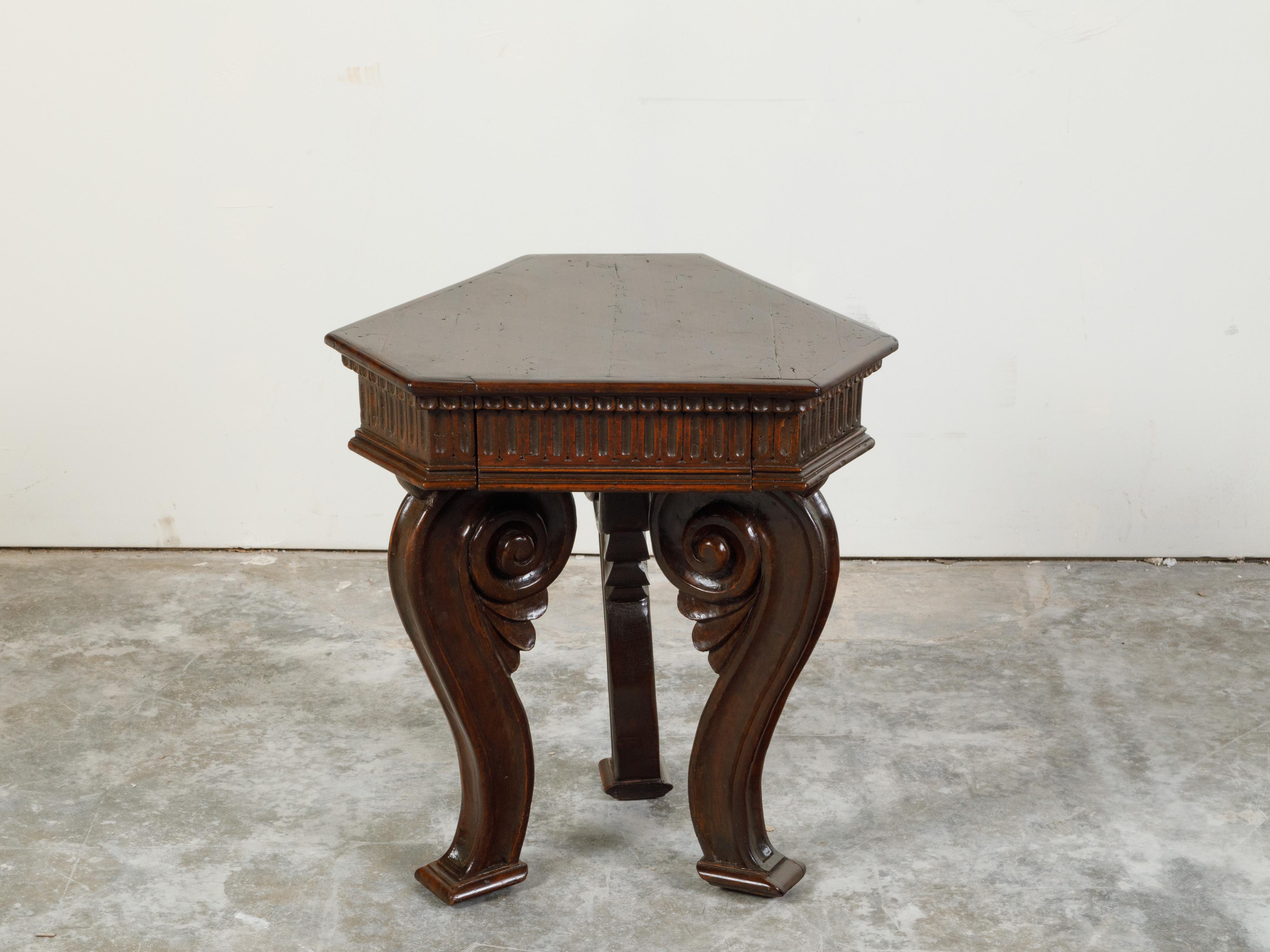 An Italian walnut low side table from the late 18th century, with hexagonal top, carved fluted motifs, single drawer and scrolling legs. Created in Italy during the last years of the 18th century, this walnut side table features an hexagonal top