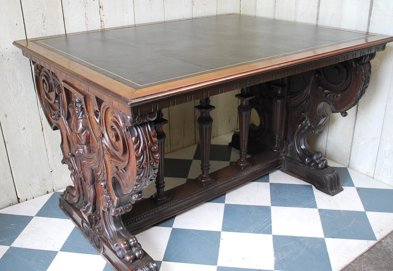 A superb decorative Italian writing desk, made in solid walnut with a black leather top. A beautiful representation of Renaissance design with bold trestle ends, exquisitely carved with a male figure standing at either end. Below are columns with